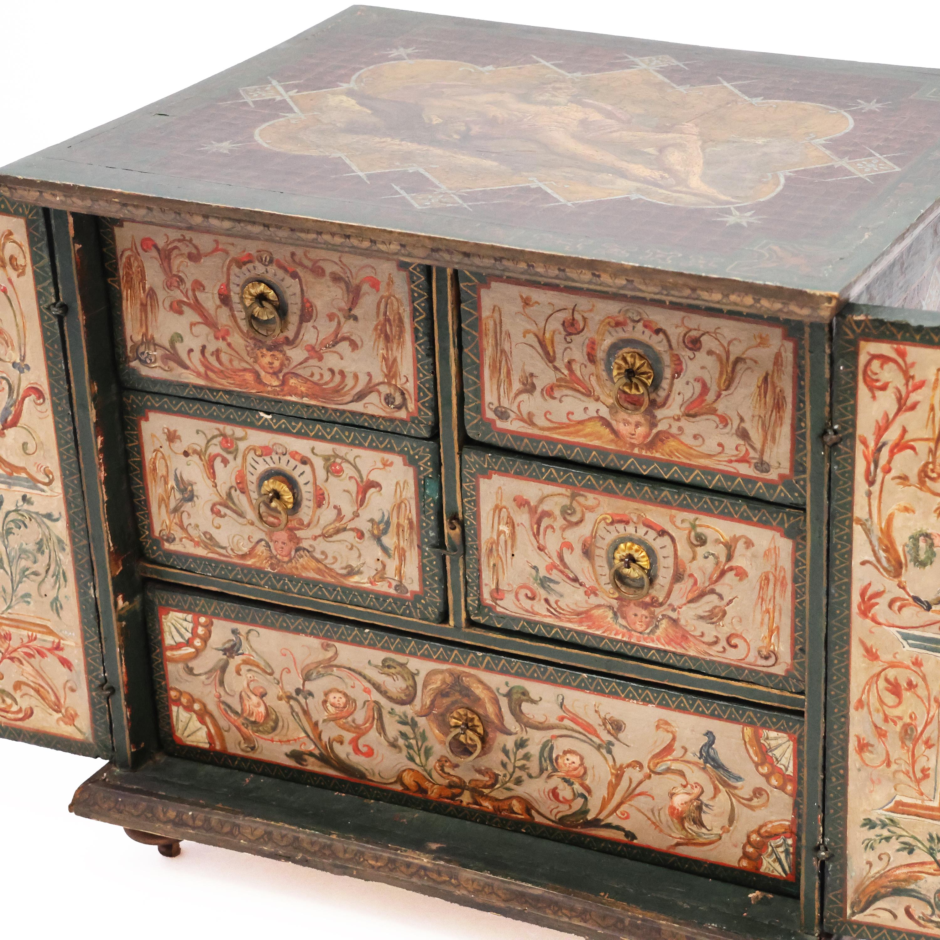 Descripción
Joyero de dos puertas de madera de álamo pintado por todas sus caras con motivos mitológicos y geométricos. Dentro de un  5 cajones dispuestos en nido de abeja. En la base de la caja figura la siguiente inscripción: 