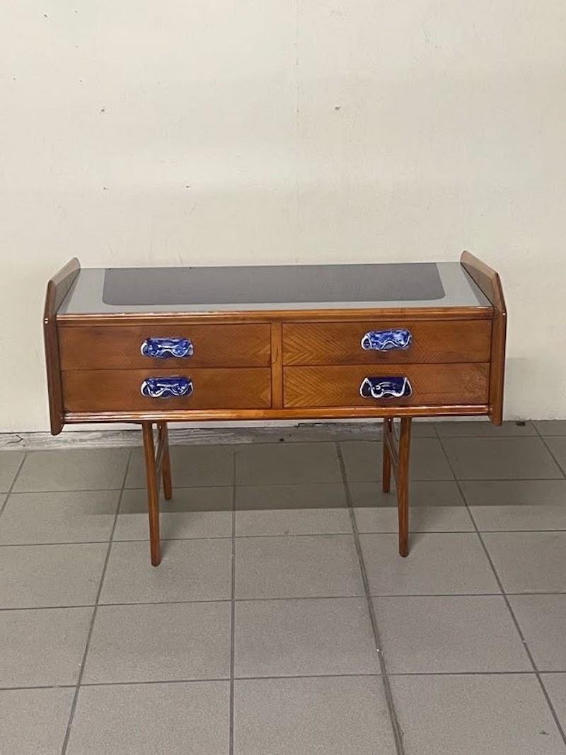 Petite commode des années 1950 en bois de chêne et poignées en céramique décorées, blanc et bleu.

Plateau en verre bleu avec bordures blanches, toujours d'origine.

Les pieds fins et usinés donnent un ton léger et élégant à ce meuble restauré avec