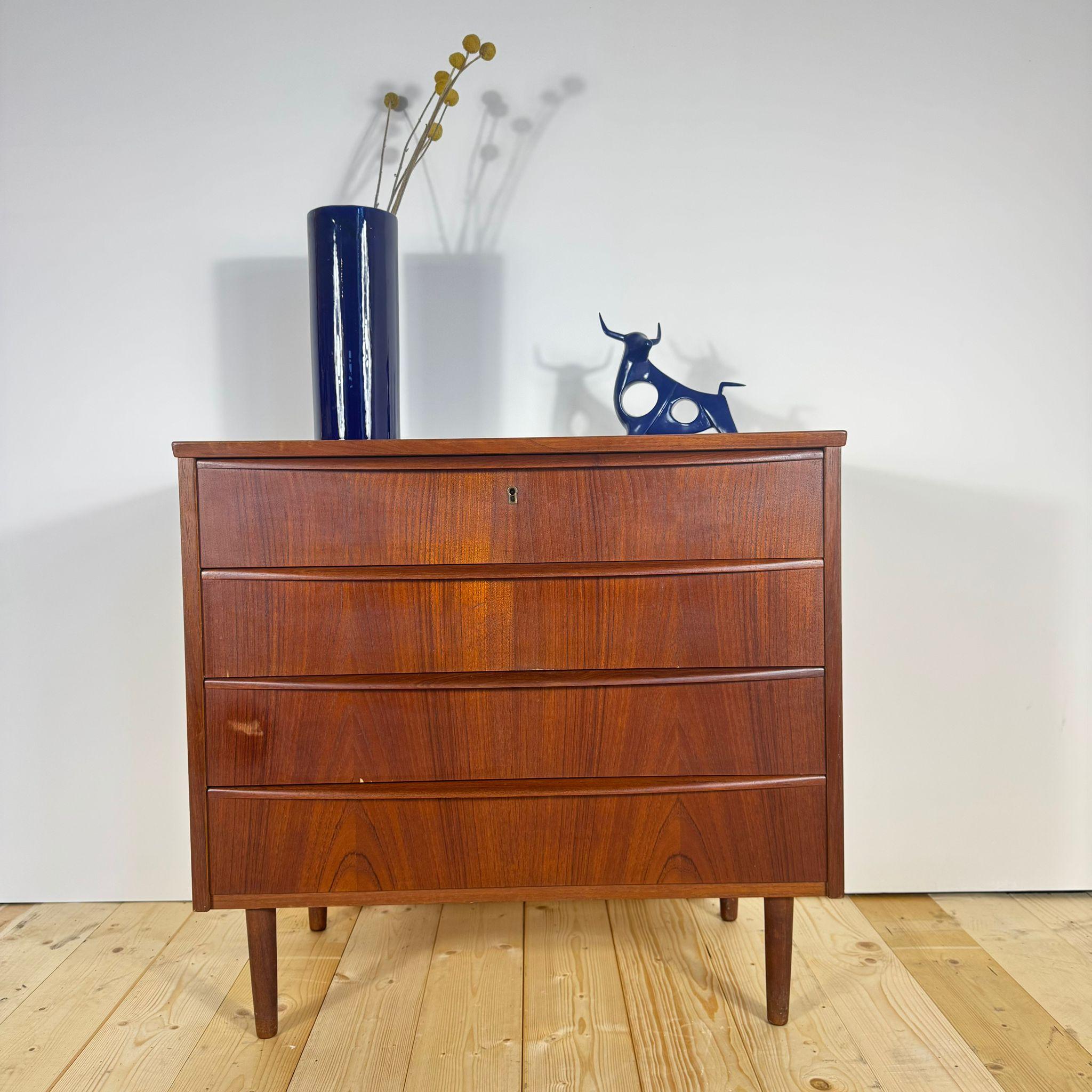 Questa cassettiera danese degli anni Sessanta in teak impiallacciato rappresenta uno dei canoni più puri del design Mid-Century scandinavo: essenzialità, equilibrio e bellezza naturale. Le sue linee sobrie e le proporzioni armoniose sono esaltate