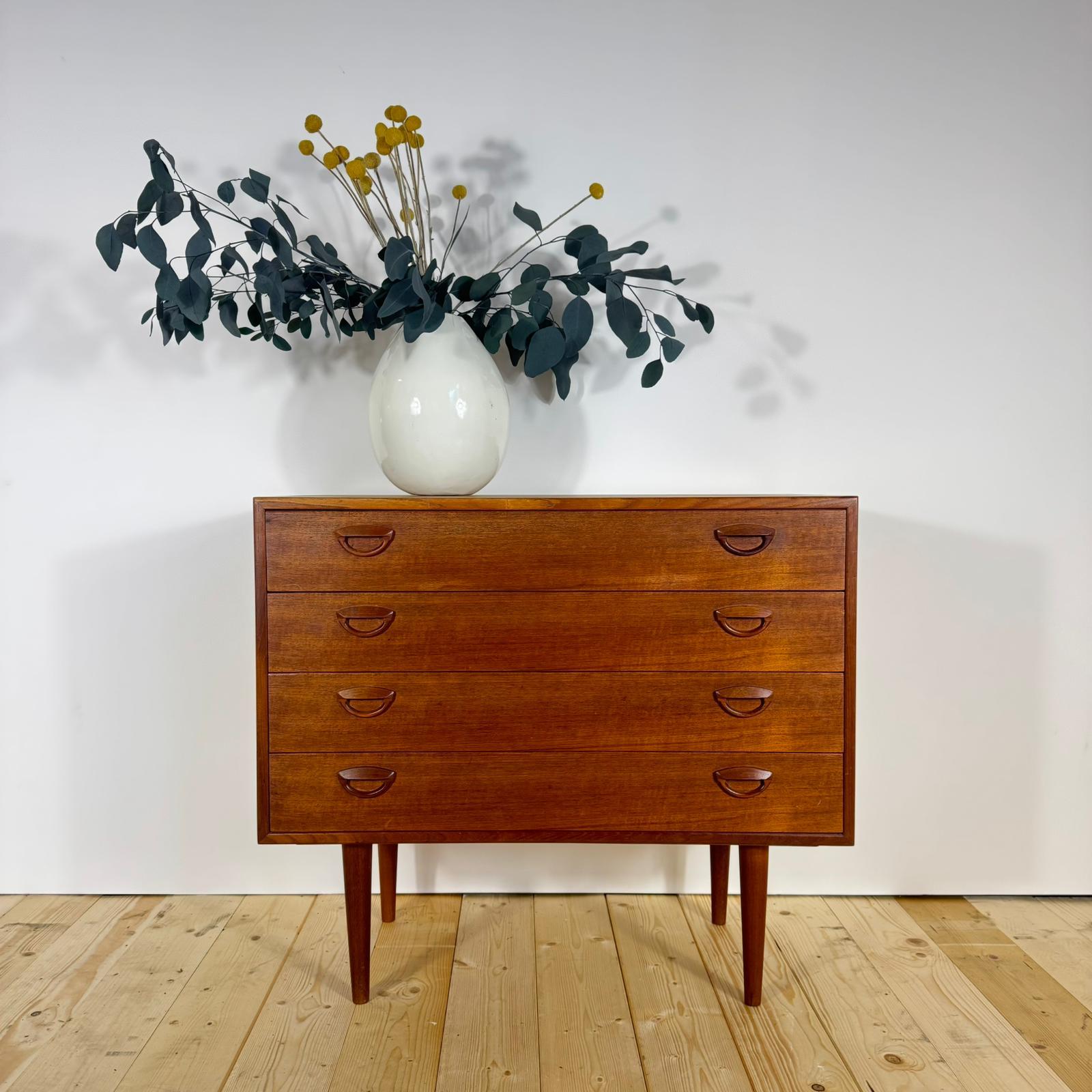 Questa piccola cassettiera danese, disegnata da Kai Kristiansen per Feldballes Møbelfabrik, è un raffinato esempio di design Mid-Century scandinavo. Realizzata in teak impiallacciato con finitura originale, esprime quella naturale eleganza che ha