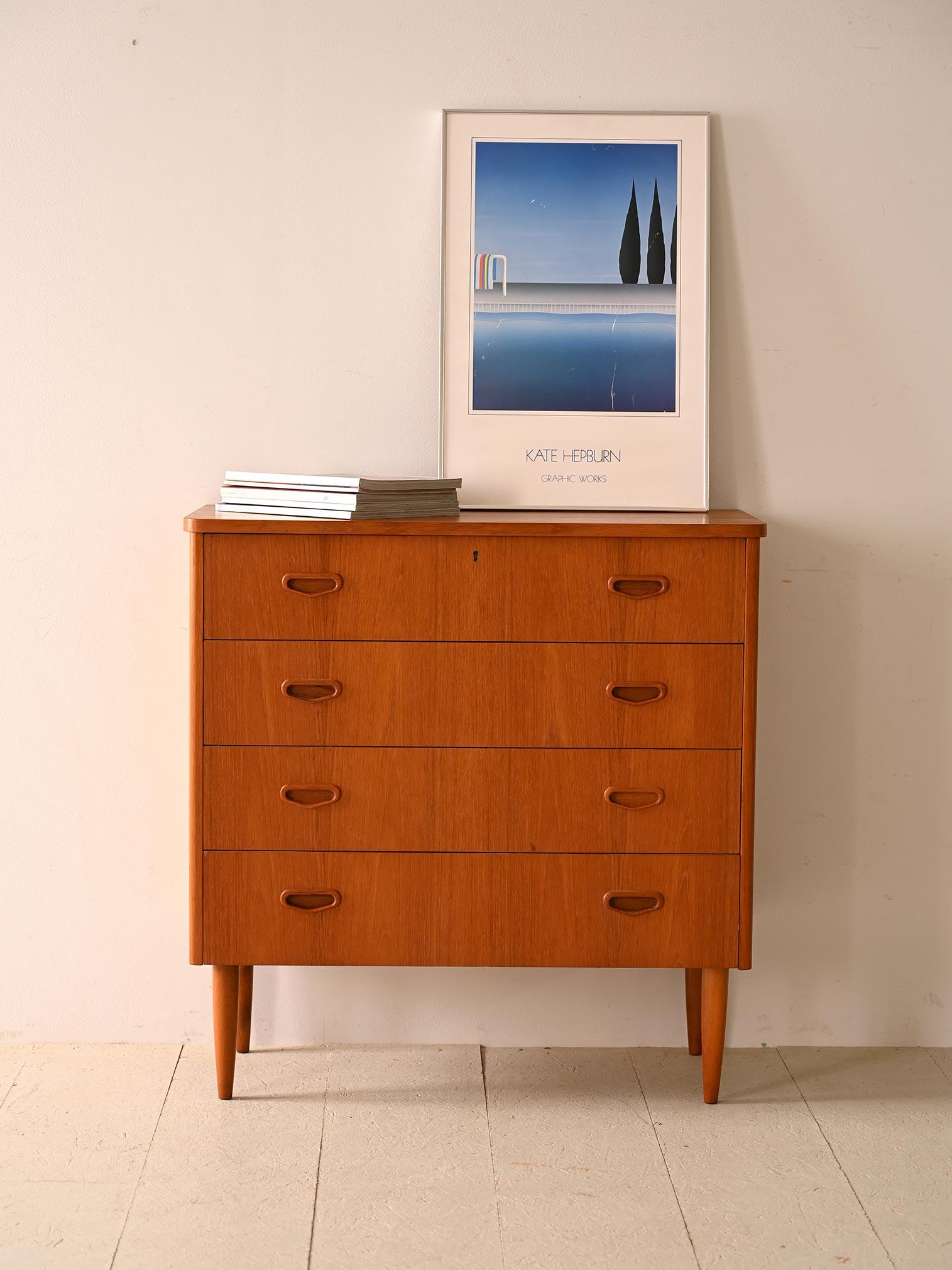 Cabinet with 4 drawers and lock.

A chest of drawers with lines typical of mid-century Scandinavian design. Wood-carved handles add artistic detail and a unique personal touch to each piece. Tapered legs lend subtle elegance and a light touch to the