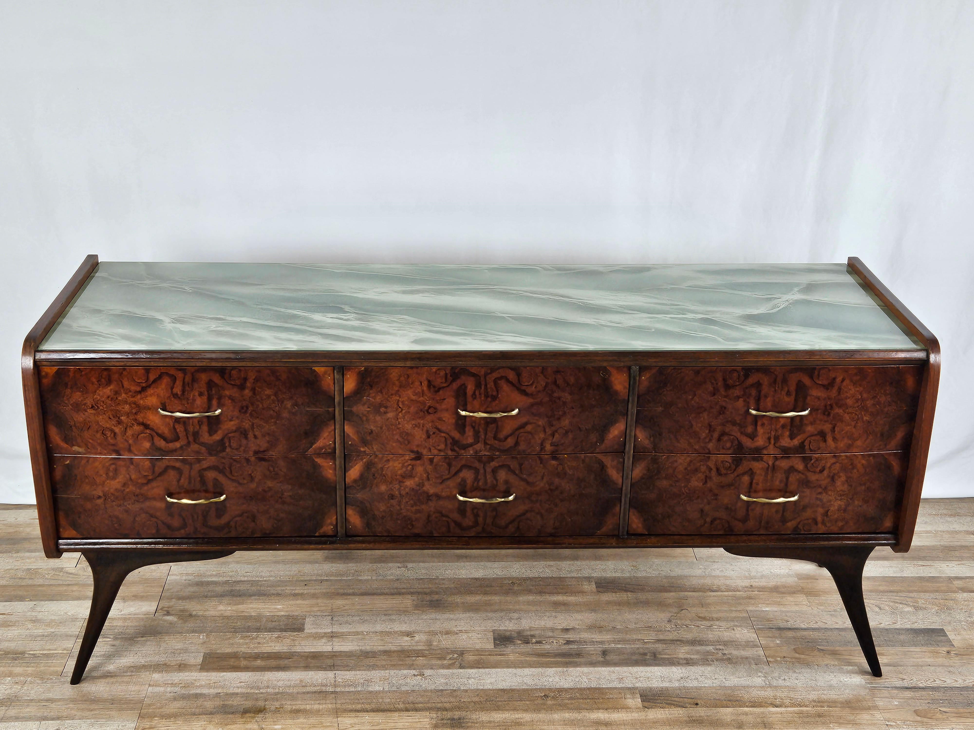 Commode moderne en bois avec six grands tiroirs robustes, décorée d'un plateau en verre sarcelle très allégorique qui donne une touche 'fraîche' et méditerranéenne au meuble.

Grâce à ses dimensions réduites et linéaires, la commode peut également