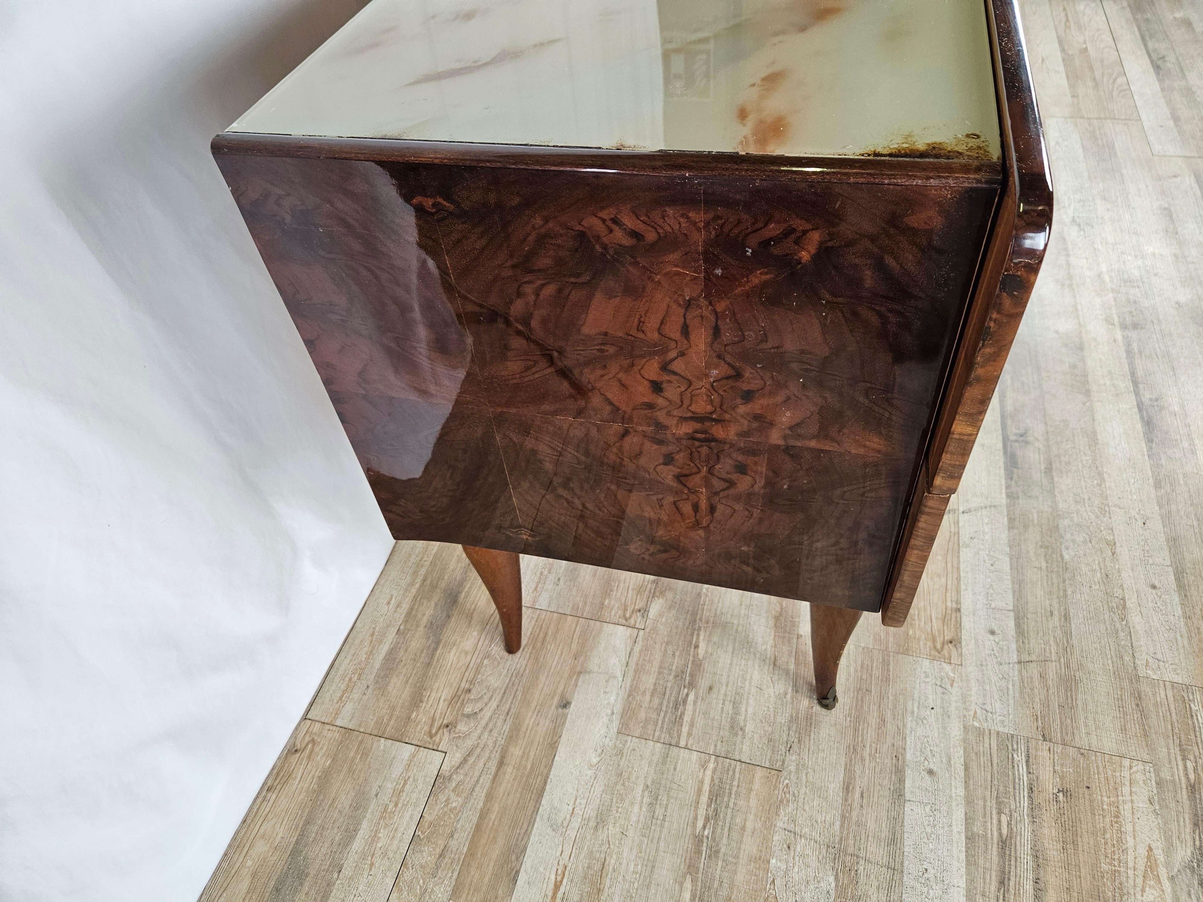 Italienische Kommode aus den frühen 1950er Jahren mit einer schönen marmorierten Glasplatte und einem sehr markanten Design mit geschwungenen Beinen.

Er verfügt über vier große, robuste Schubladen mit originalen Messinggriffen aus der Zeit, ein