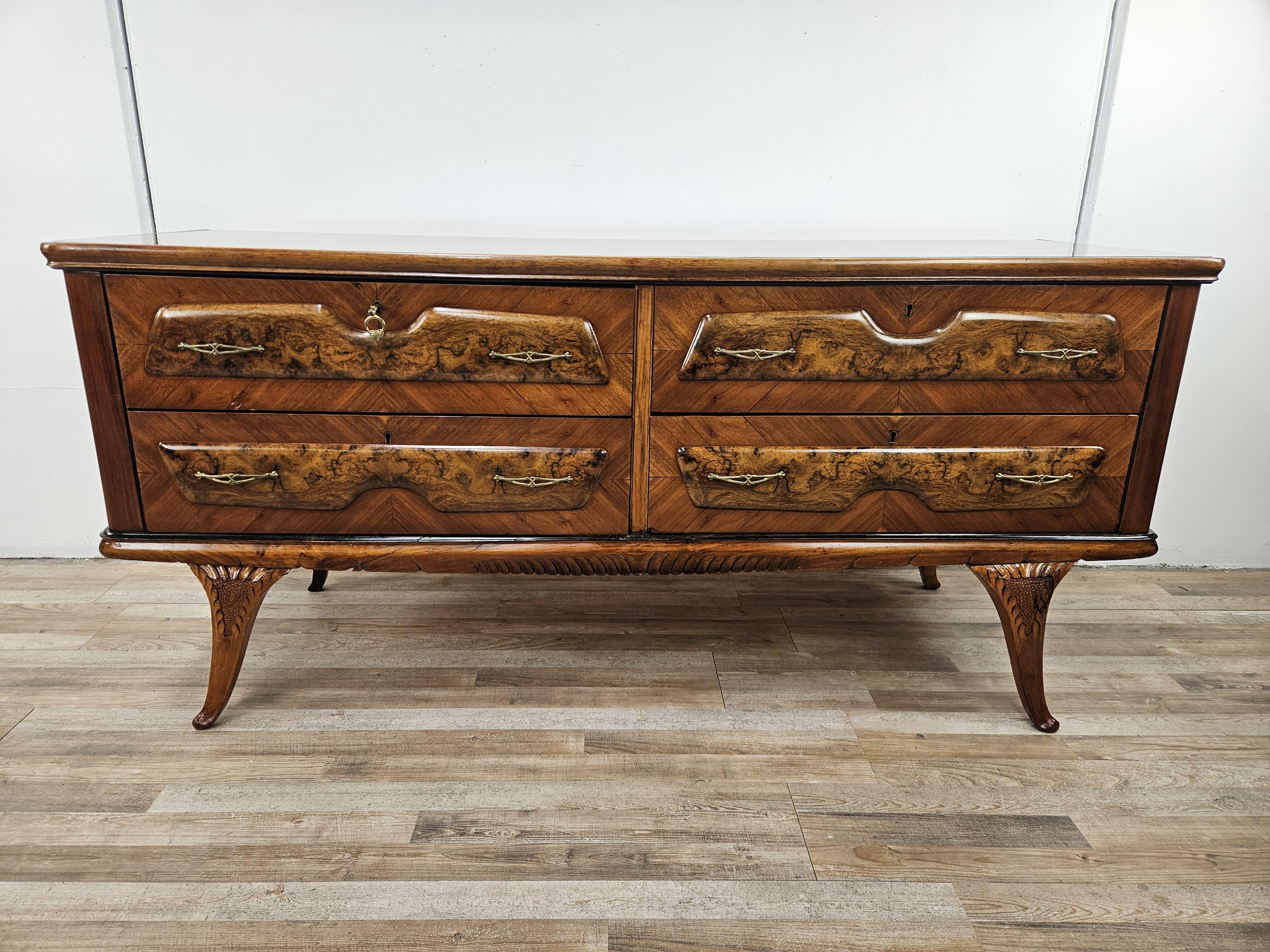 Mobile da camera anni '50 con quattro ampi e robusti cassetti decorati da maniglie in ottone e con serratura originale.

Il piano in vetro marrone è finemente decorato e lavorato, da notare inoltre le gambe anteriori e i vari intagli lungo il bordo