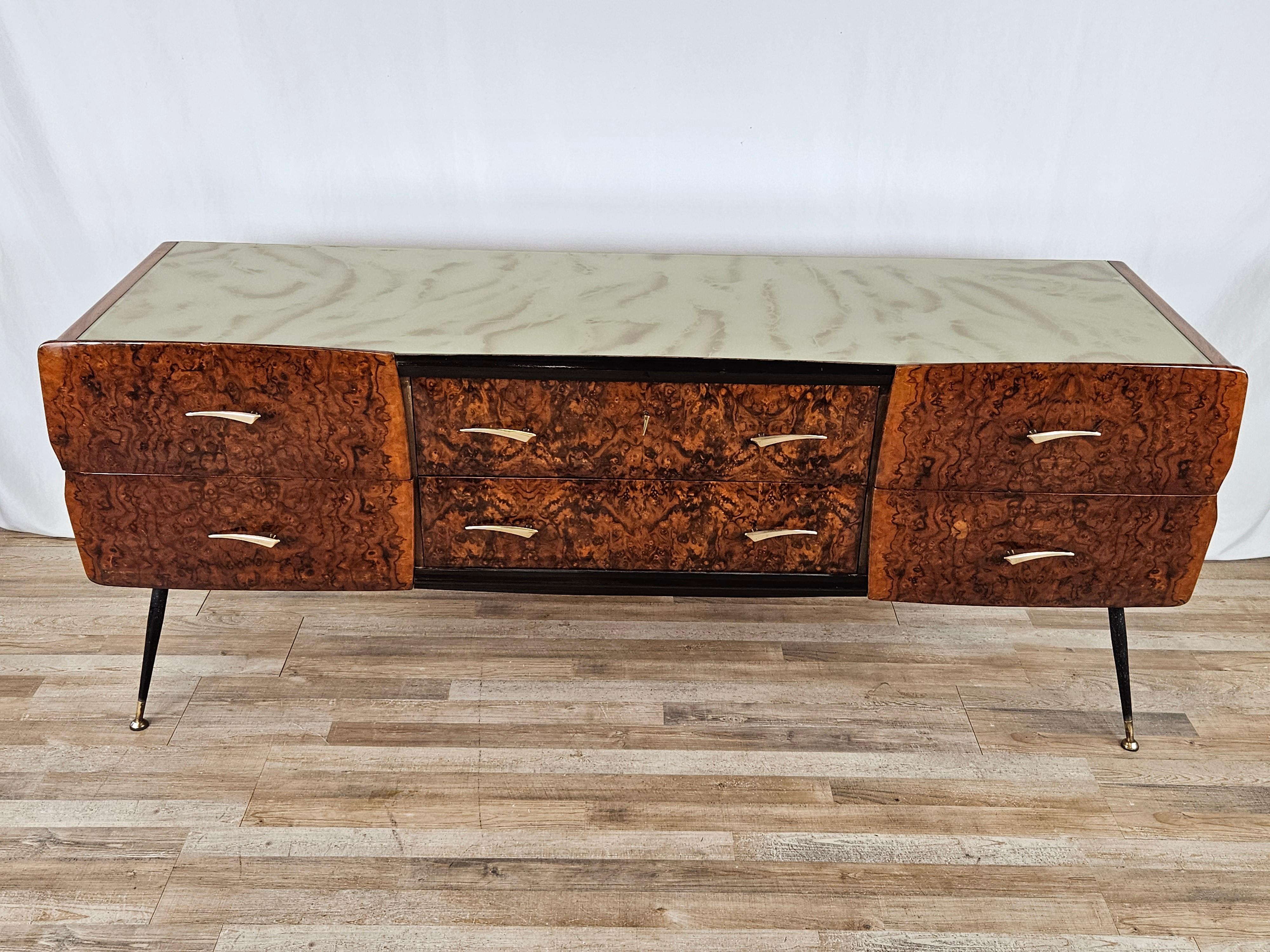 Modern bedroom chest of drawers made of mahogany burl, 1950s Italian production of high quality and workmanship.

The cabinet is made of mahogany with a distinctive worked and decorated glass top, note the iron spiked legs with brass ferrules and