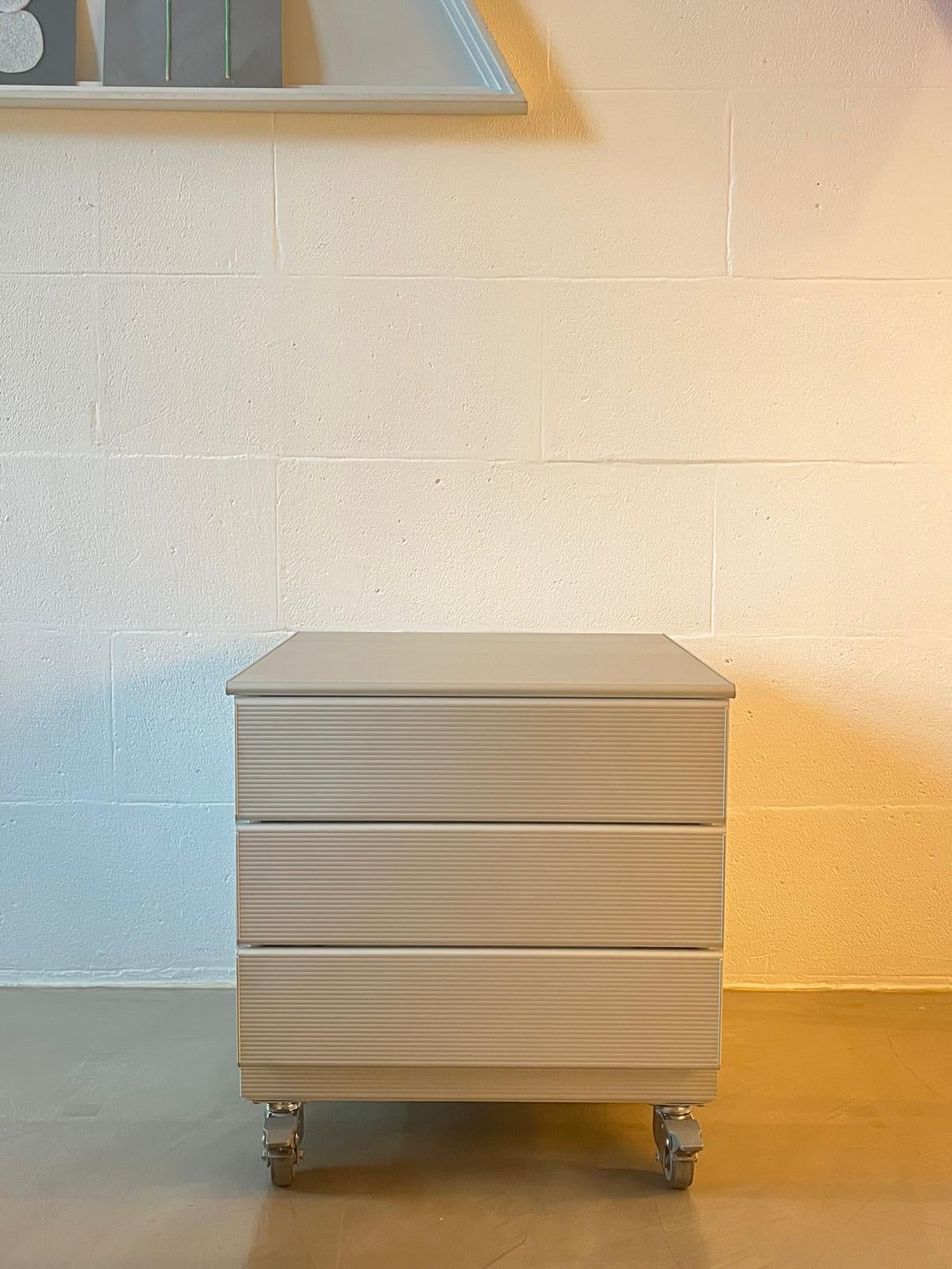 Cassettiera mod. Velasca - Ycami di L. Cozza & L. Mascheroni.
Realizzata in alluminio ondulato con iconica texture verticale, questa cassettiera compatta (h. 54 × L. 51 × P. 51 cm) unisce estetica industriale e funzionalità contemporanea. La