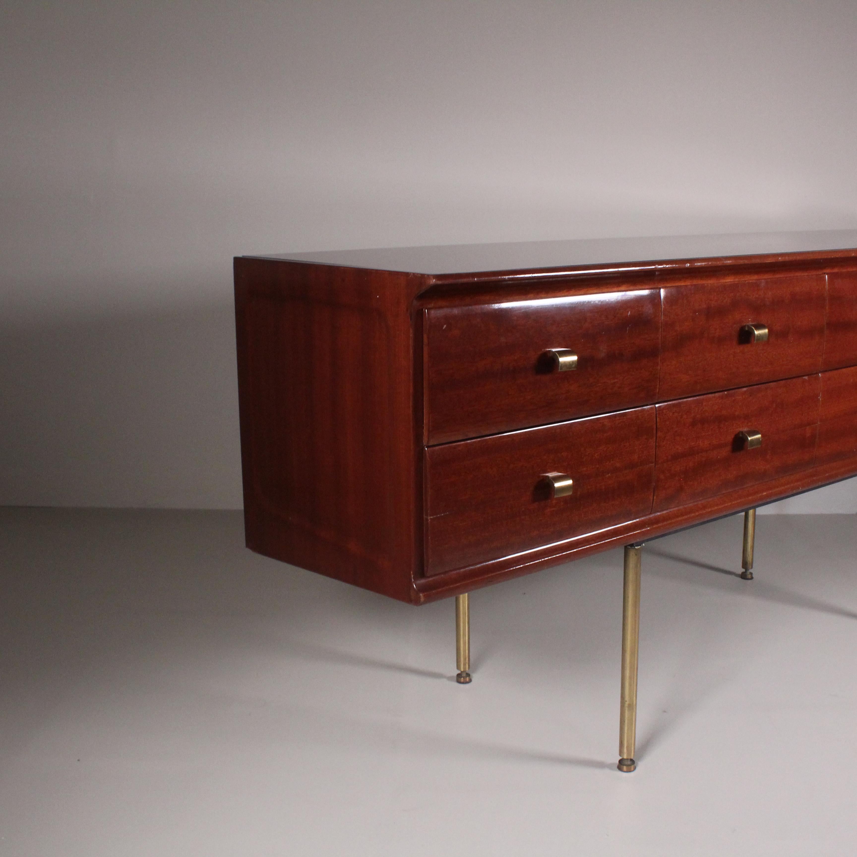 This chest of drawers by Osvaldo Borsani, dating from the 1950s, embodies the elegance and innovation of Italian design at the time. Featuring a combination of fine materials, such as brass and burgundy-colored glass, this creation expresses