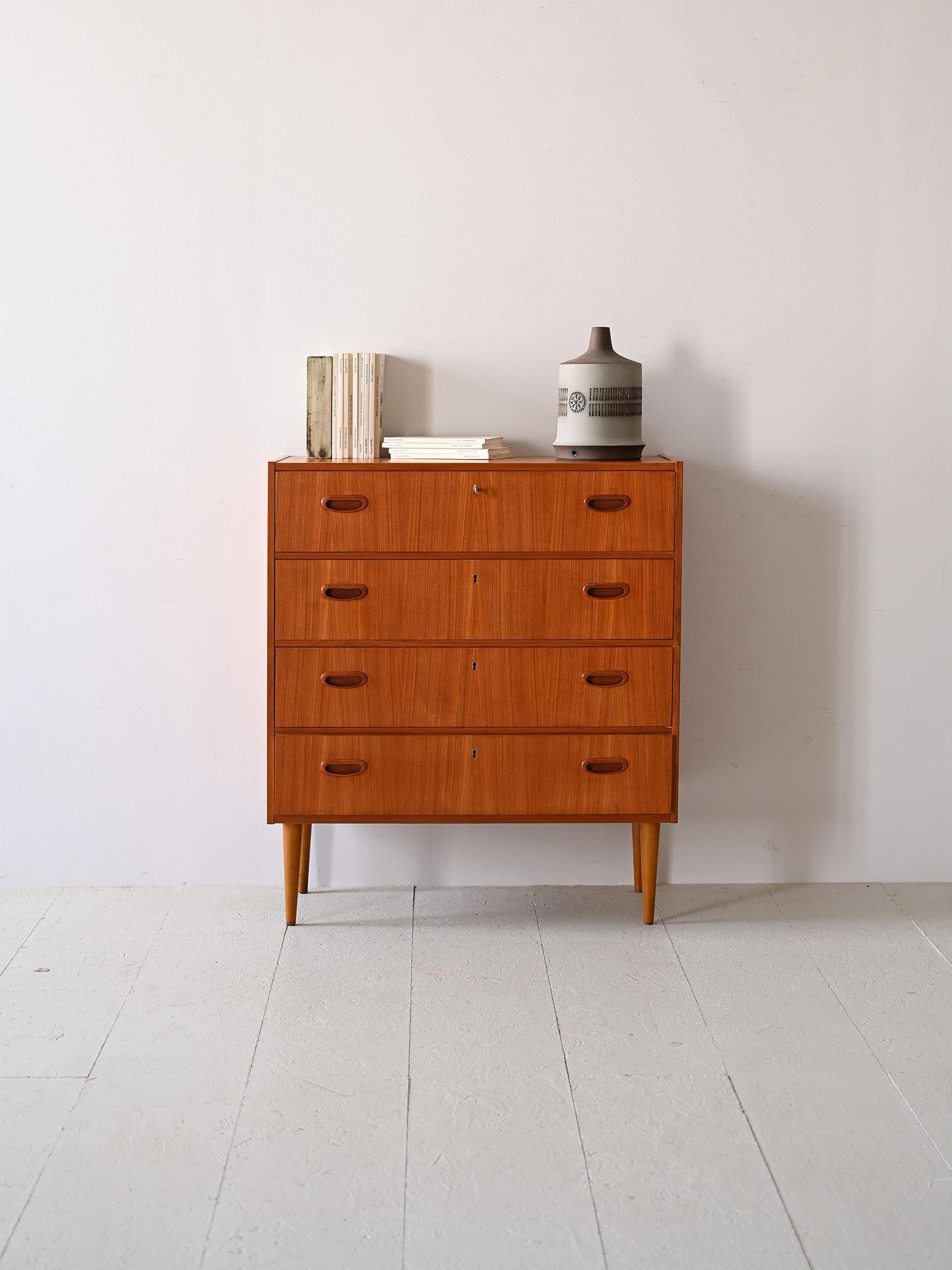 Questa cassettiera scandinava degli anni '50, realizzata in teak, è un esemplare di sobria eleganza. Il design lineare, esaltato dalle maniglie incassate, rispecchia l'essenza del minimalismo nordico. L'artigianato dell'epoca si rivela nella scelta