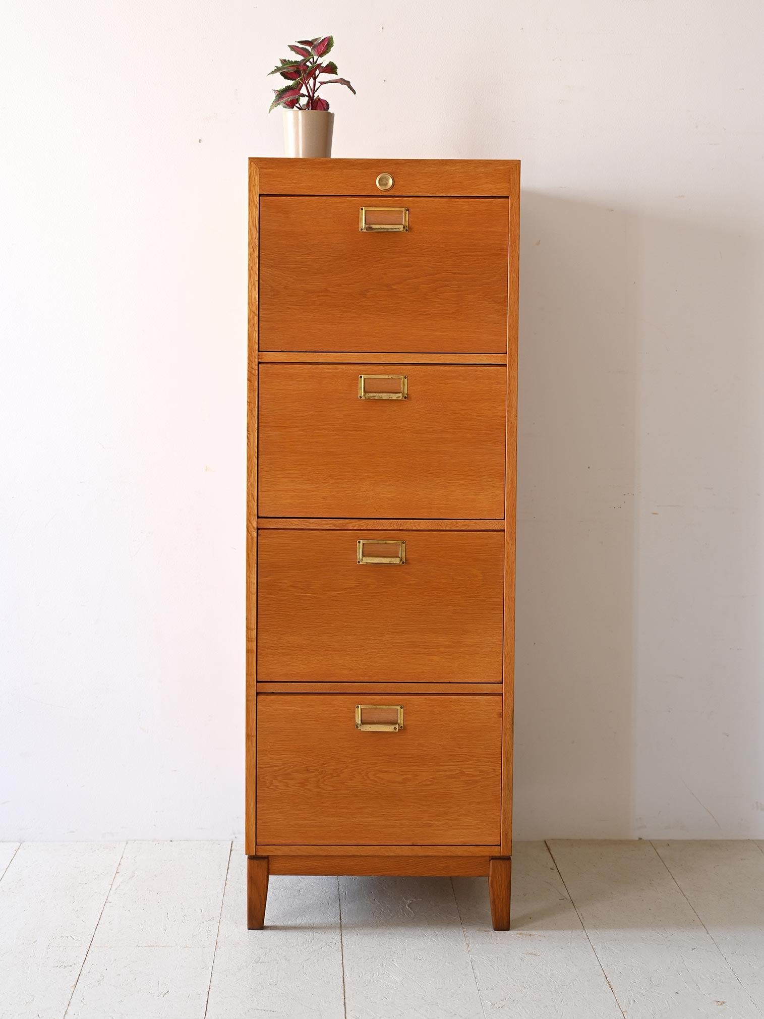 Archivio in rovere con impugnature in metallo dorato.

Dotata di quattro ampi cassetti, questa cassettiera offre spazio abbondante per organizzare documenti, materiale d'ufficio, vestiti o altri oggetti personali. Le dimensioni generose del mobile