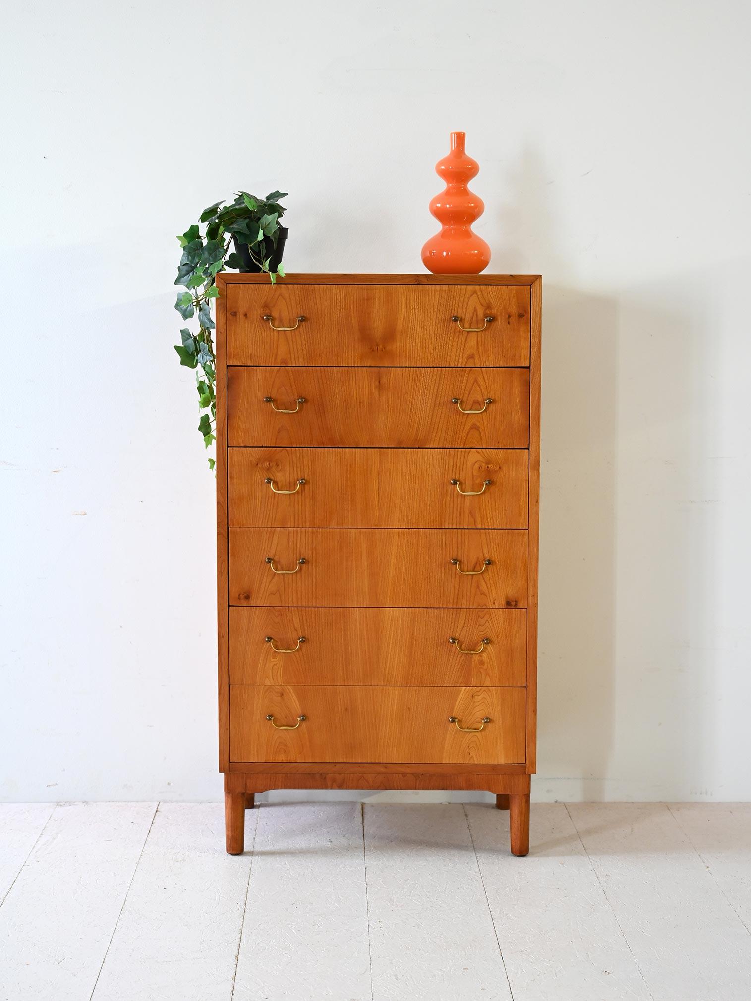 Scandinavian 1950s/60s light walnut chest of drawers, six drawers with brass handles and contrasting legs.

Vintage Scandinavian chest of drawers made in the 1950s/60s in warm-toned walnut. It features six vertical drawers with shaped brass handles