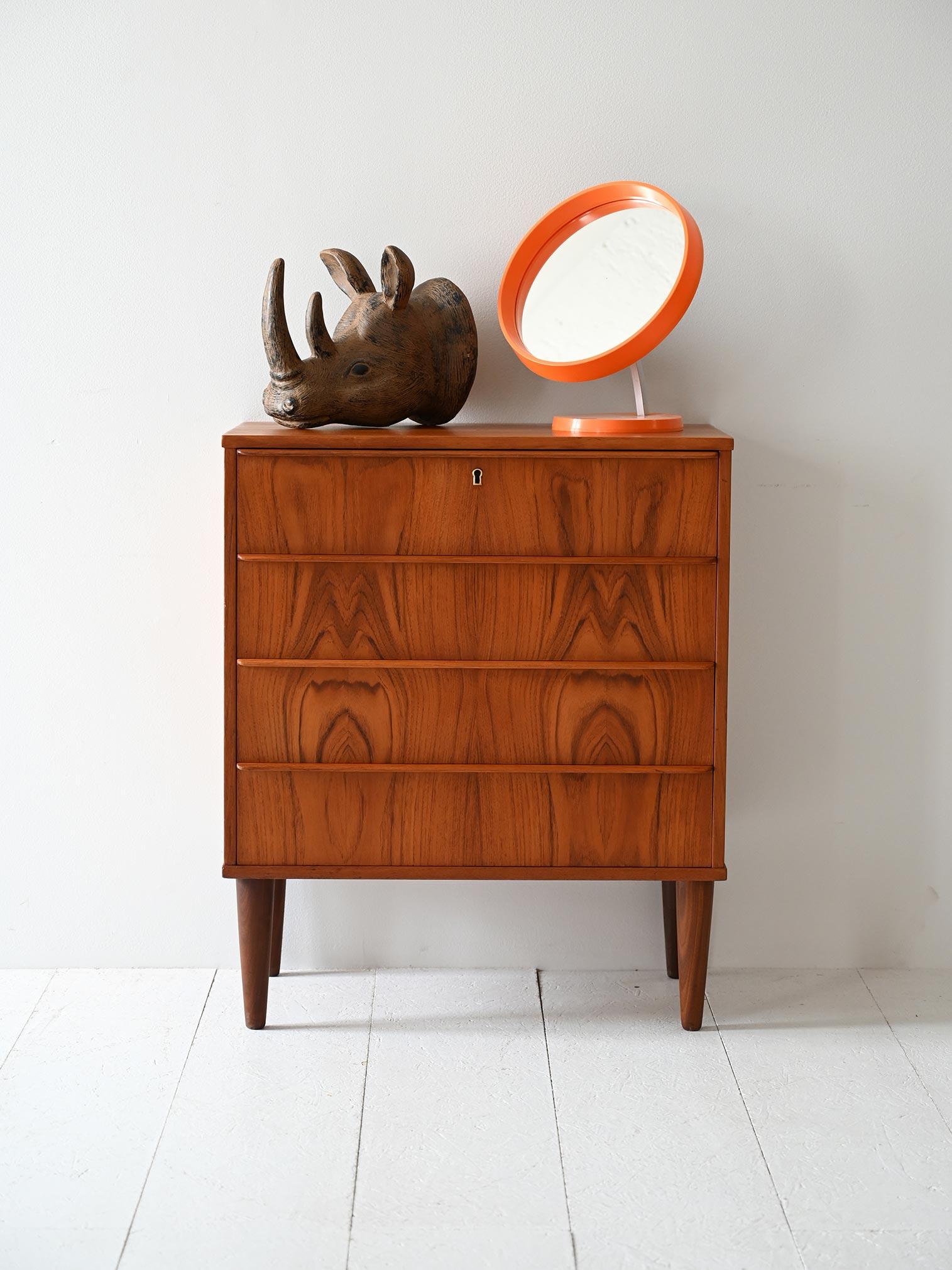 Cassettiera con tre cassetti, maniglie a presa integrata e venatura simmetrica in teak fiammato.

Struttura compatta e linee pulite caratterizzano questa cassettiera scandinava vintage anni ’50/’60. I tre cassetti presentano maniglie orizzontali a