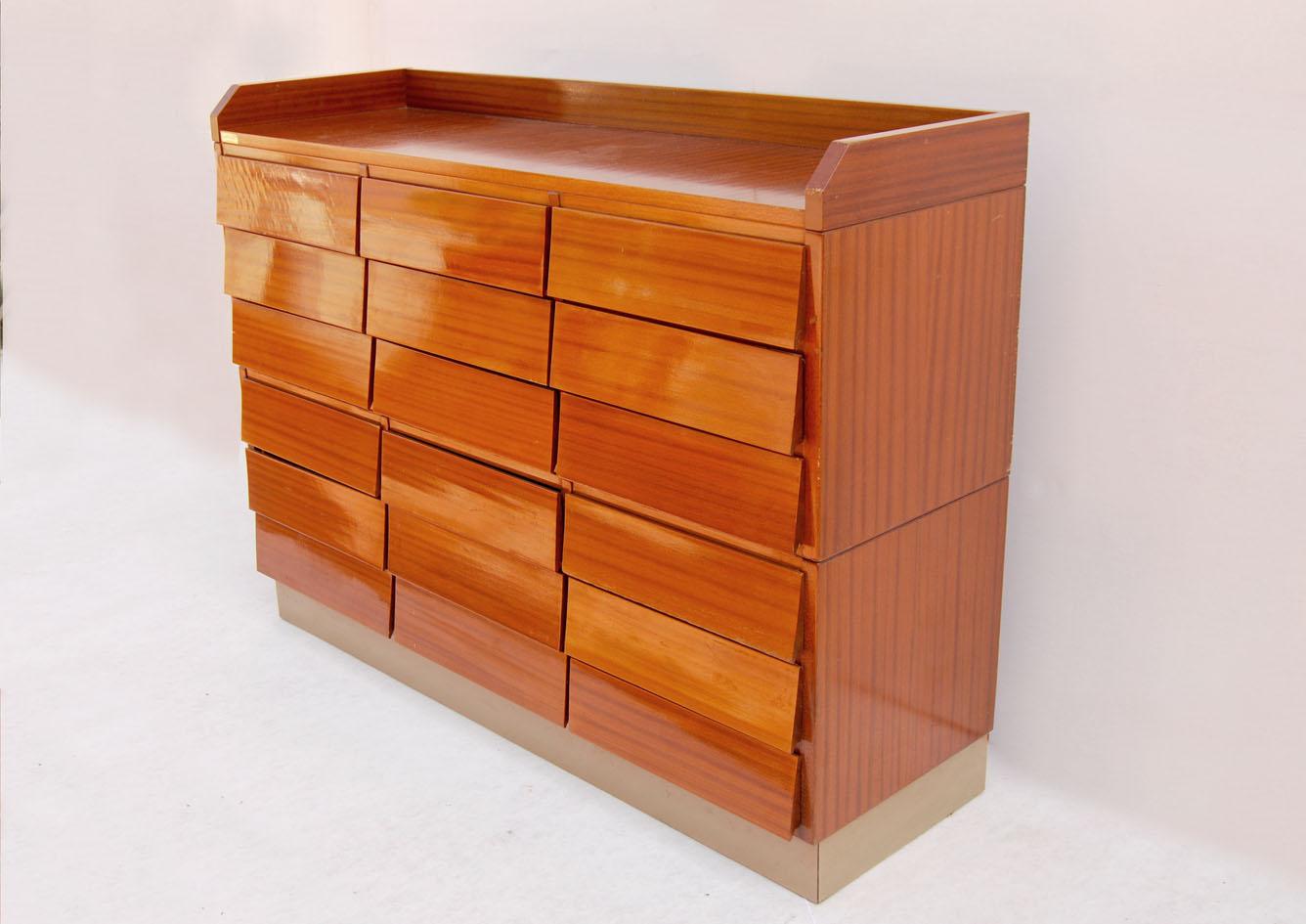 Questa bella cassettiera schedario da archivio, Schirolli, risale agli anni '50 del secolo scorso.
Costruita dalla nota azienda italiana nello stile di Gio Ponti, è in legno con impiallicciatura in mogano lucido. Composta da 18 cassetti con frontale