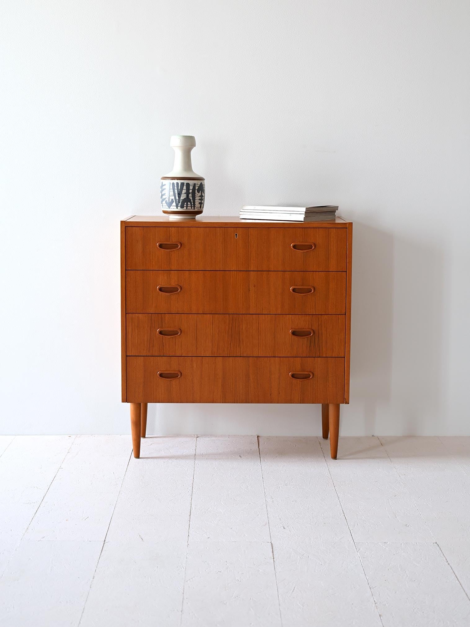 Mobile scandinavo con 4 cassetti di cui il primo dotato di serratura.  Le gambe coniche slanciano la figura. Il design sobrio e moderno ricalca il gusto di metà secolo.

Realizzata con maestria artigianale, questa cassettiera incarna lo stile sobrio