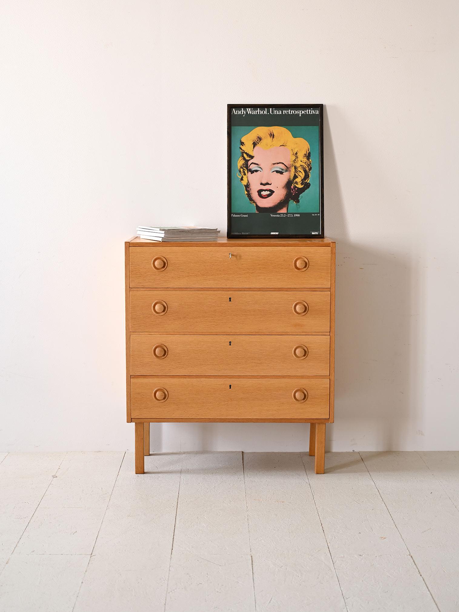 Scandinavian chest of drawers with four drawers.

Simple and functional, this piece features square, regular shapes in both frame and legs, contrasting with the protruding, rounded handle that lends character to the cabinet.

The warm tone of teak