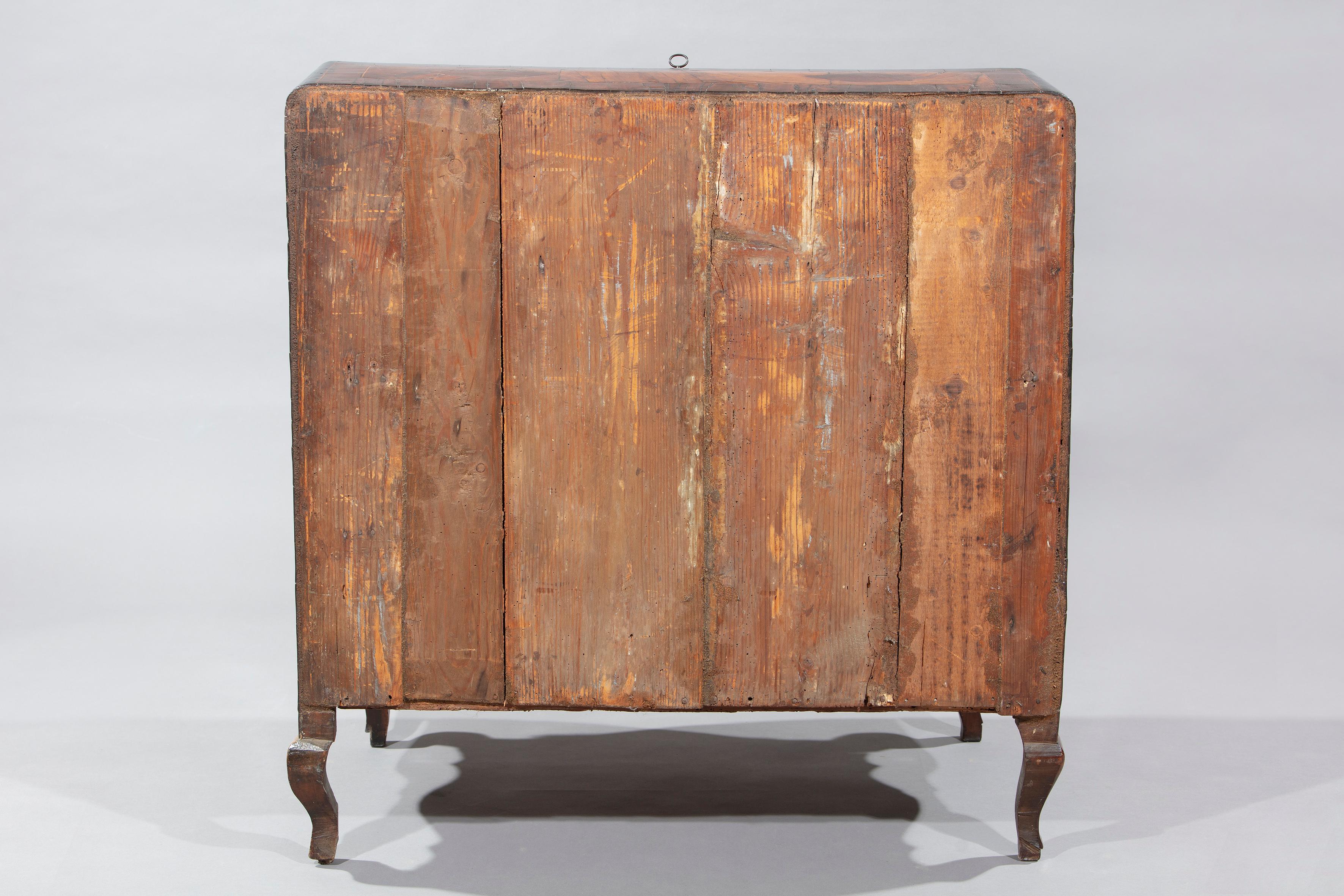 Walnut and burl walnut panelled flap chest of drawers, Piedmont, 18th century. Rounded front with three drawers decorated with mixtilinear reserves within panels. In the cove two drawers and three compartments. Shaped apron and straight sides inlaid