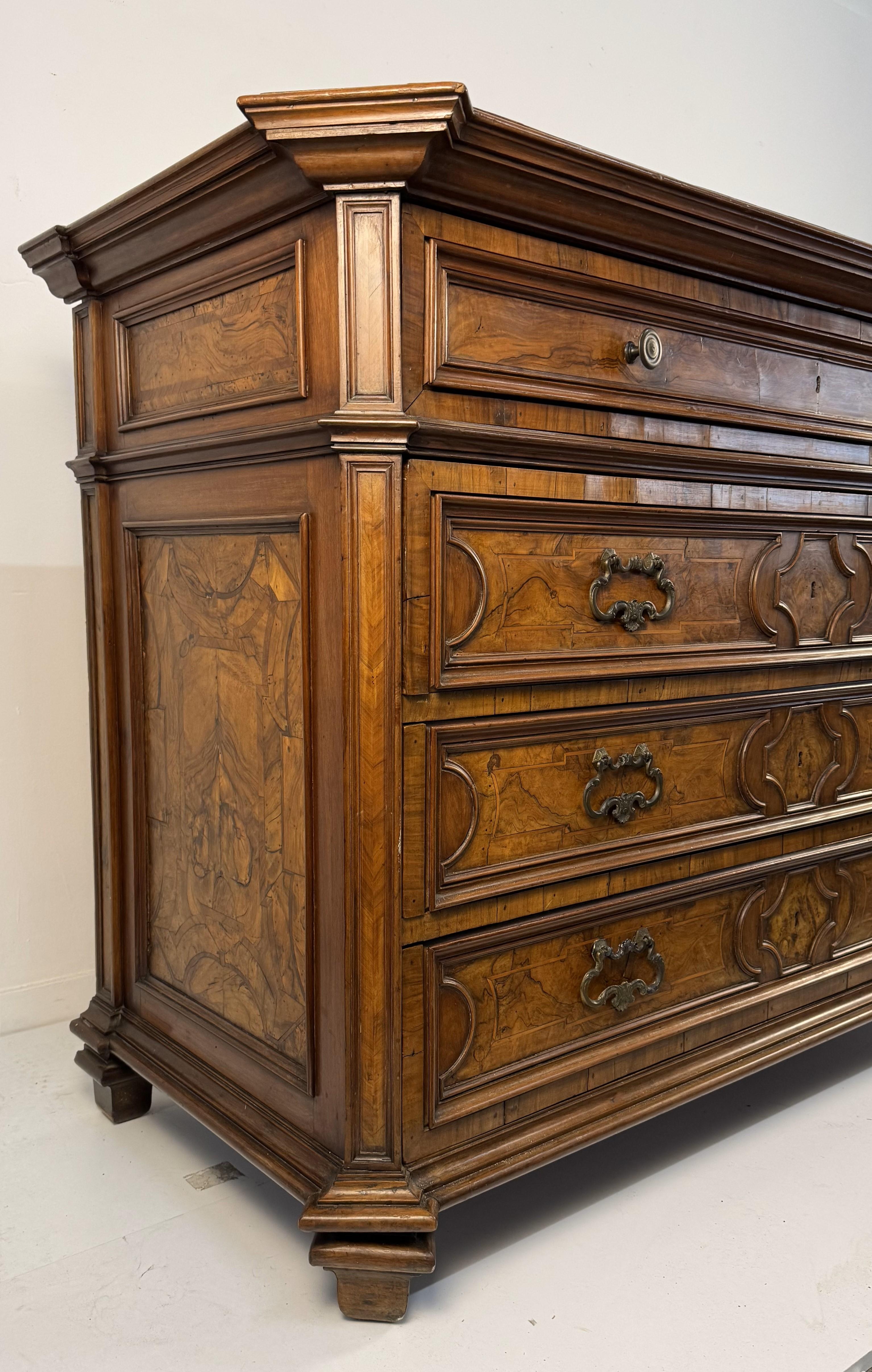 Cassettone in noce e in parte lastronato in noce, fine XVII secolo, fronte a quattro cassetti separati da traverse e decorati da pannelli in radica entro profili centinati. Il primo cassetto a calatoia cela all'interno diciassette piccoli cassetti.