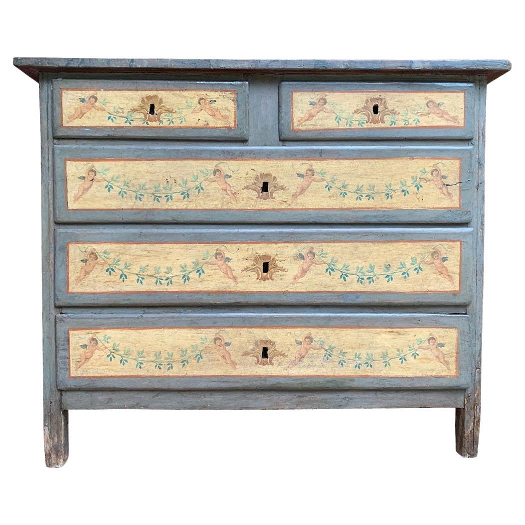 Cette exquise commode italienne du XVIIIe siècle est un remarquable exemple d'élégance rustique et de savoir-faire artisanal. Sa décoration originale peinte à la main attire immédiatement le regard, mettant en valeur une palette délicate de bleus
