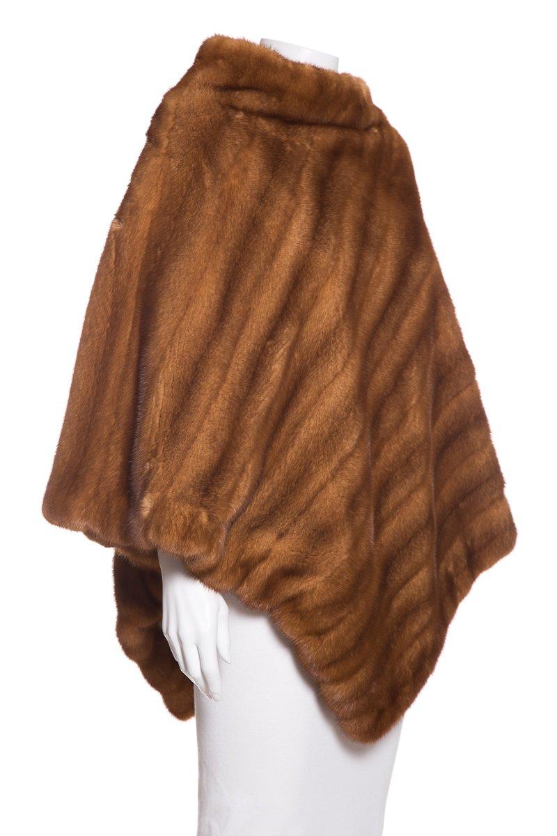 Cassin mink poncho, rounded neck, tonal stitching, and tonal silk lining with interior pouch pocket.
This item is previously worn and in good condition.