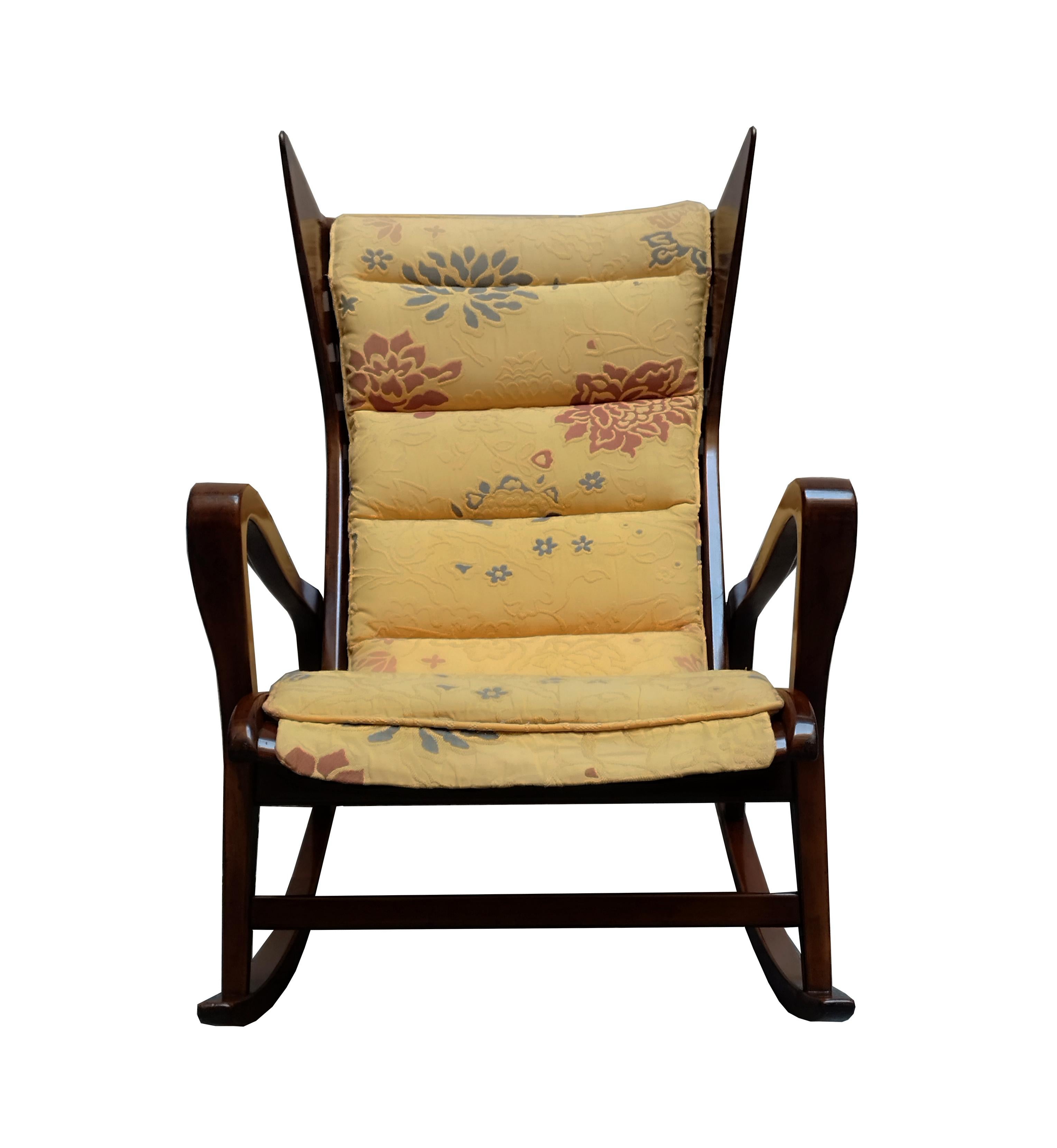 Très rare fauteuil à bascule en noyer, caoutchouc et tissu pour Cassina, Italie. Les techniques de production exquises utilisées sont attestées par les magnifiques détails en bois qui caractérisent l'ensemble du design. Rembourrage original en tissu
