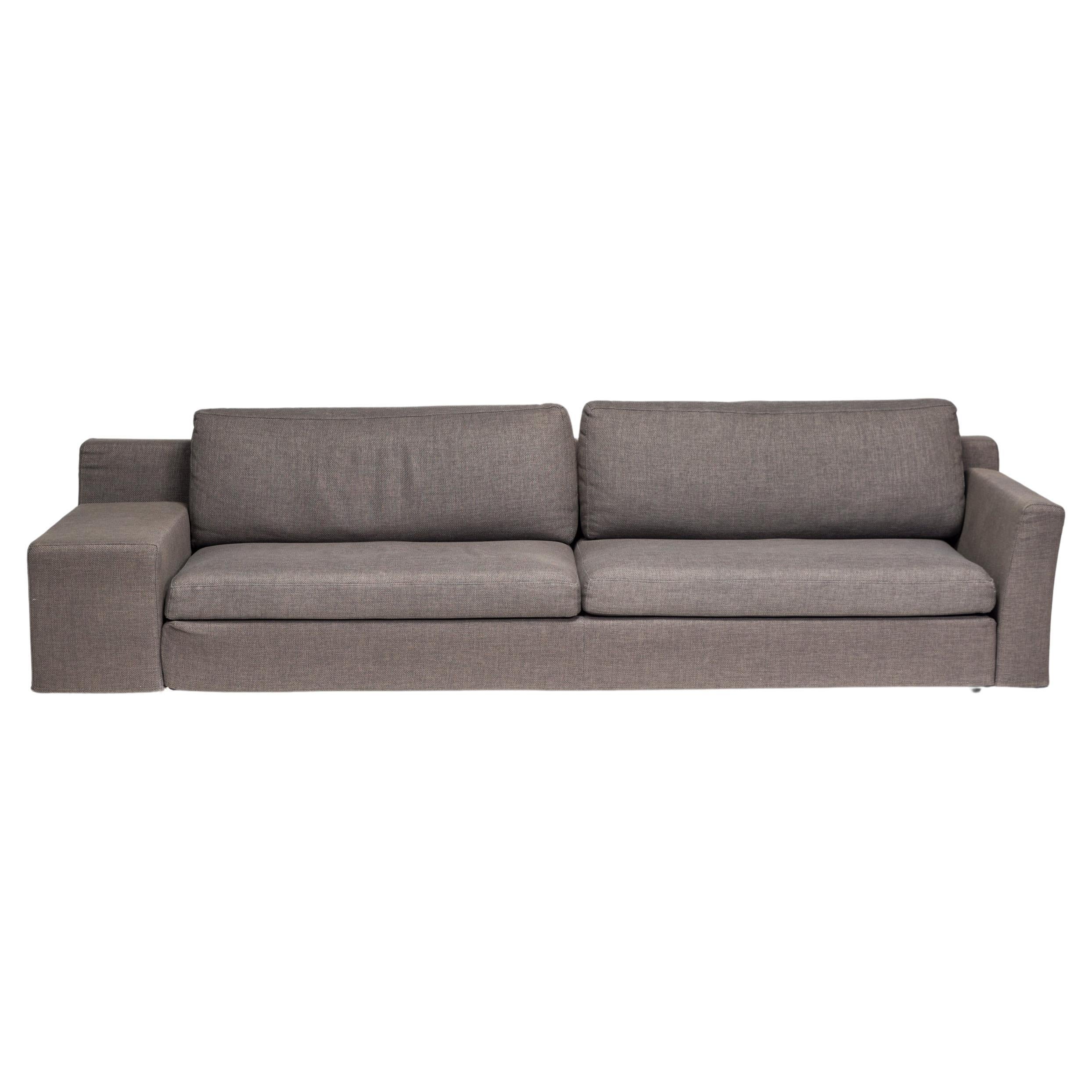 A fantastic example of contemporary design, this Mister sofa is designed by Philippe Starck for Cassina.

The sofa has a low back and deep seating, fully upholstered in dark grey woven fabric.

The sofa has an asymmetric silhouette, with one armrest