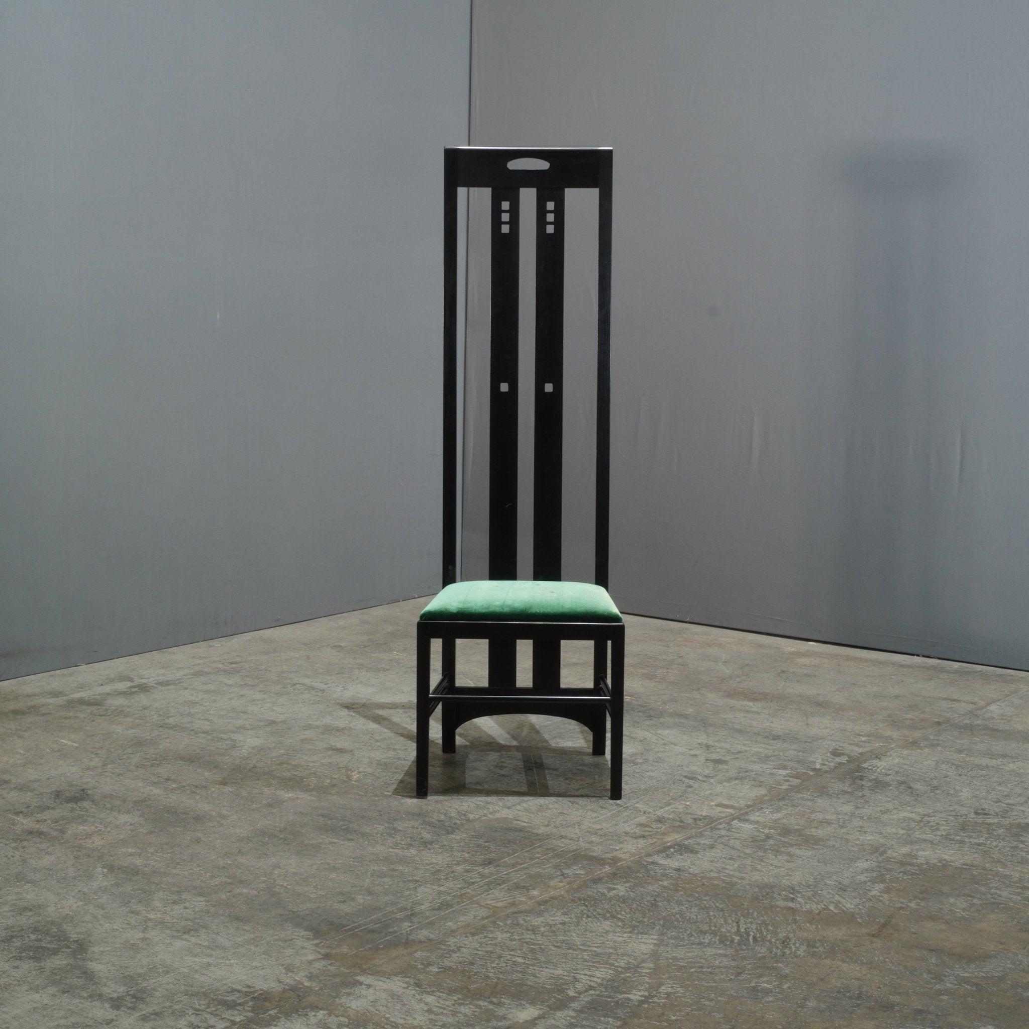 A timeless statement piece, the Cassina Ingram Chair by Charles Rennie Mackintosh embodies the essence of refined design.  This striking high back chair, crafted from black ashwood, exemplifies Mackintosh's signature aesthetic of clean lines and
