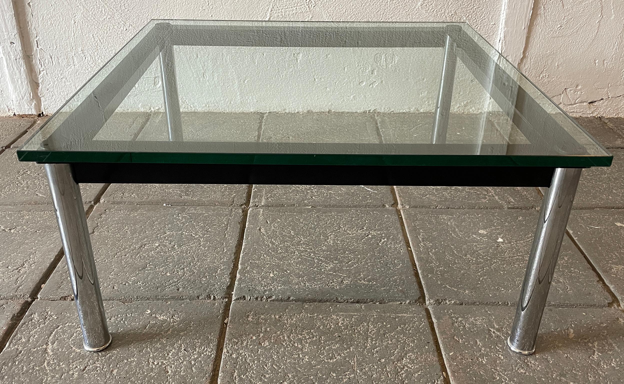 Cassina LC 10 glass and metal low coffee table square 24” square on a black metal and chrome leg base. Labeled and stamped. Located in Brooklyn NYC.