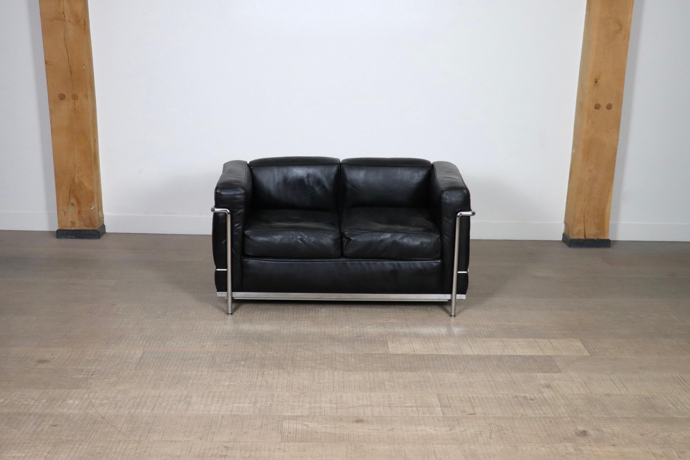 Amazing LC2 two seater sofa, a true design classic by Le Corbusier, Pierre Jeanneret and Charlotte Perriand, originally designed in 1928. The modern sofa is composed of a tubular chrome frame and high-end black leather cushions. Both sofas are