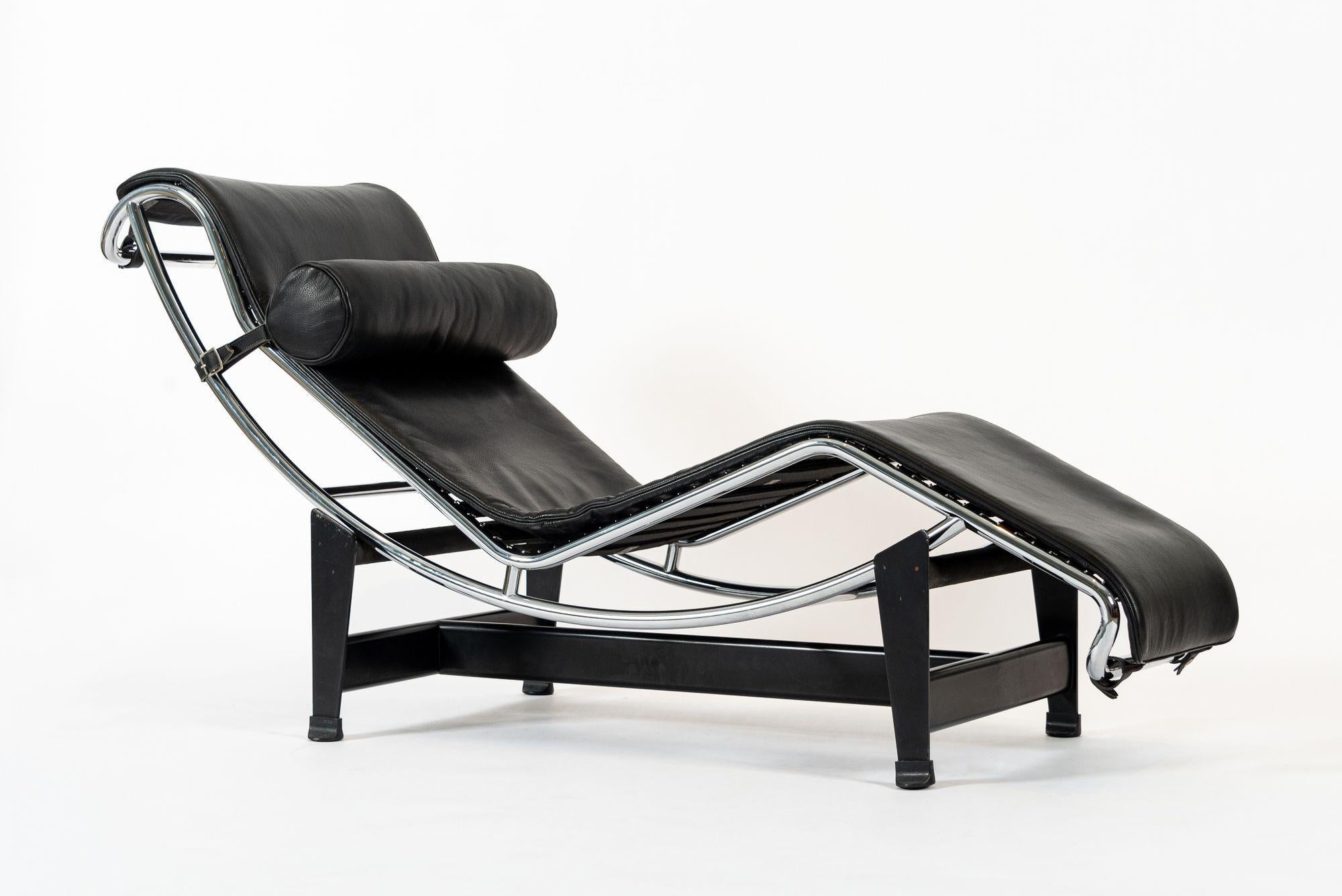 This original Cassina LC4 chaise lounge chair designed by Le Corbusier was produced in May of 2006 and features a black leather pad and headrest on a tubular steel frame with polished chrome finish over a black lacquered steel base. Impressed mark