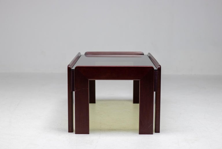 Elegant mahogany coffee table with smoked glass top designed by Afra & Tobia Scarpa for Cassina. 

Chic, distinctive, and cool, the work of husband-and-wife-team Tobia and Afra Scarpa has found a new generation of sophisticated admirers in the 21st
