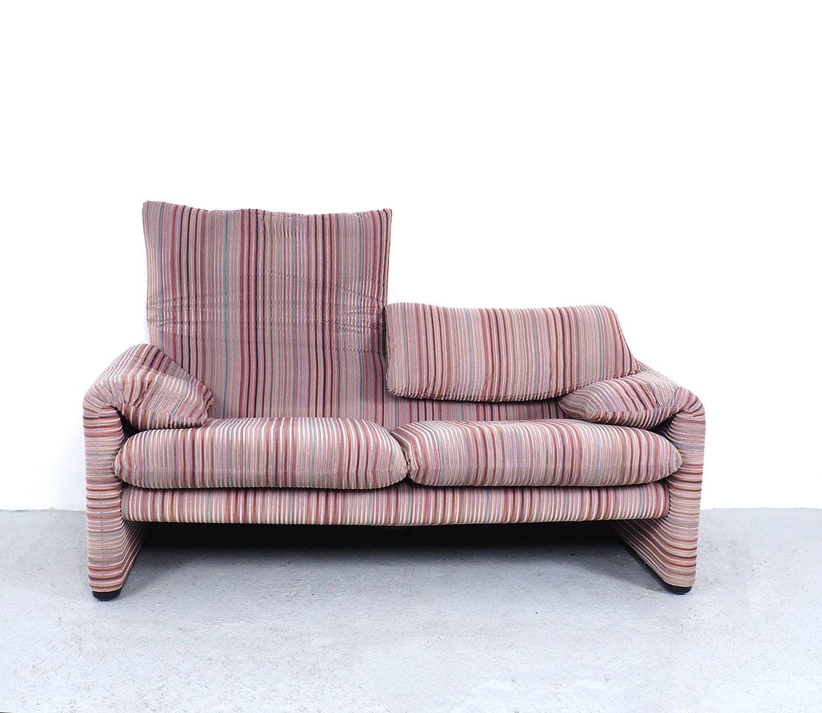 Beautiful italian designer 2-seater sofa designed in 1973.
Designed by Vico Magistretti fo Cassina.

Production period 1990/2000.

The sofa is covered with a soft velvet fabric with colorful striped decor in different soft shades pink, green,