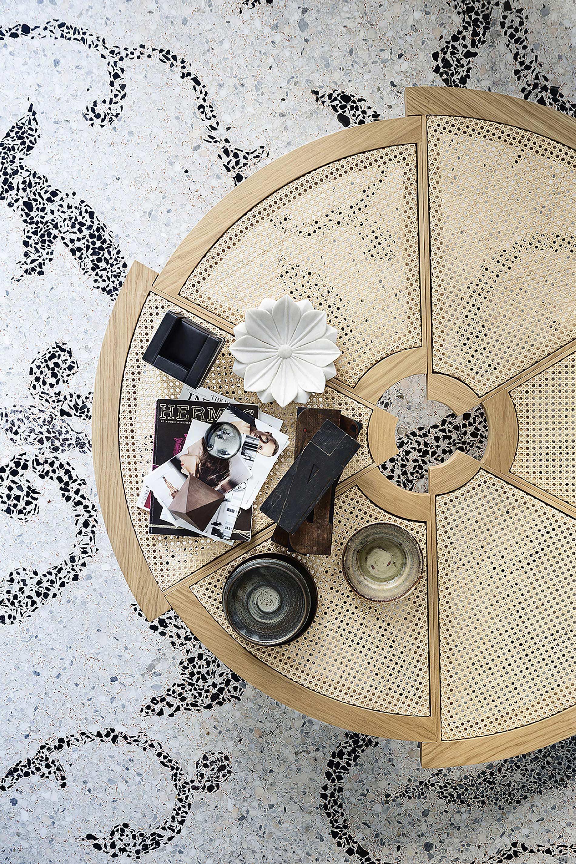 The low table by Charlotte Perriand is composed of six segments of different radius, arranged in a circle but offset from one another to create an uneven outer border in solid wood with a hole in the center, envisioned as a spatial center of
