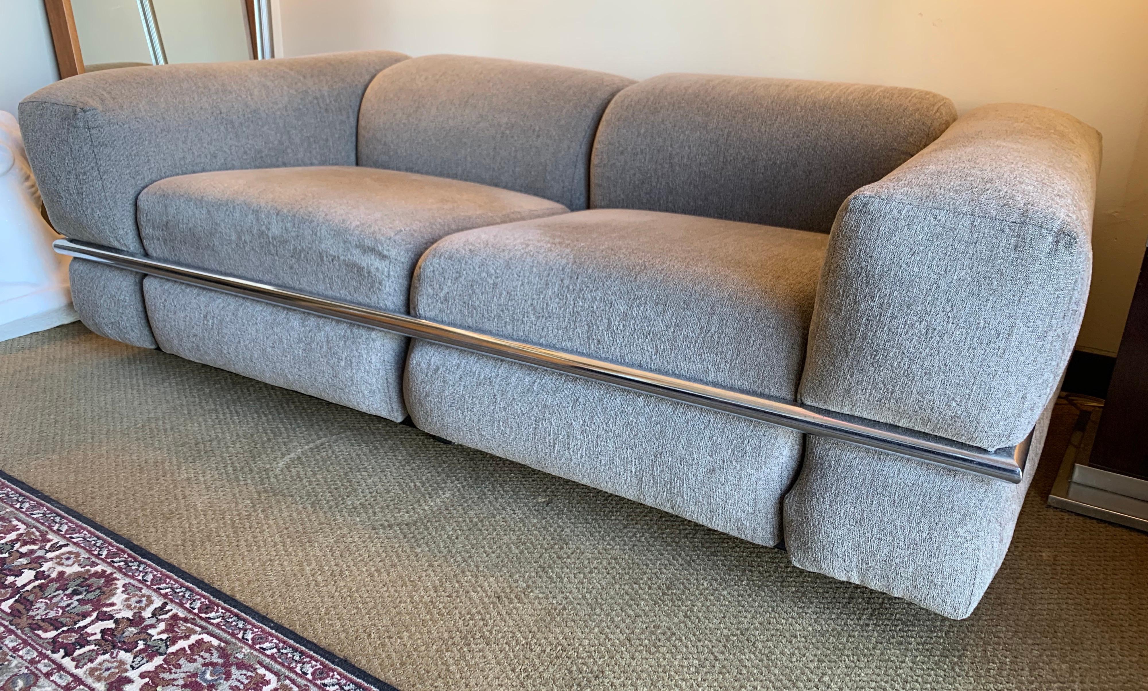 Stunning Cassina Sesann loveseat by Gianfranco Frattini. Designed in 1969 in Italy. The fabric is a solid gray and its signature is the chrome plated steel that runs around the sofa. All original, circa 1970's and still in great shape. The is the