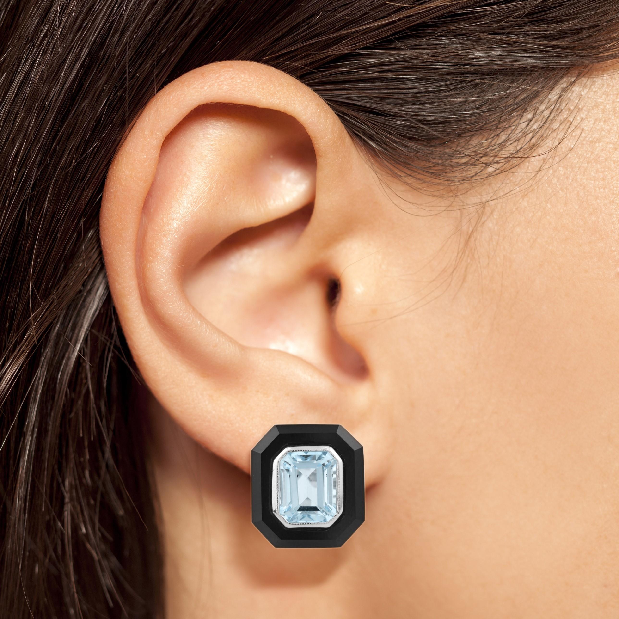 With radiant sparkle and bold contrast, these 18k white gold stud earrings are irresistible. Each features an emerald cut sky blue topaz, edged in outer frame of black onyx. 

Information
Style: Art Deco
Metal: 18K White Gold
Width: 14 mm.
Length: