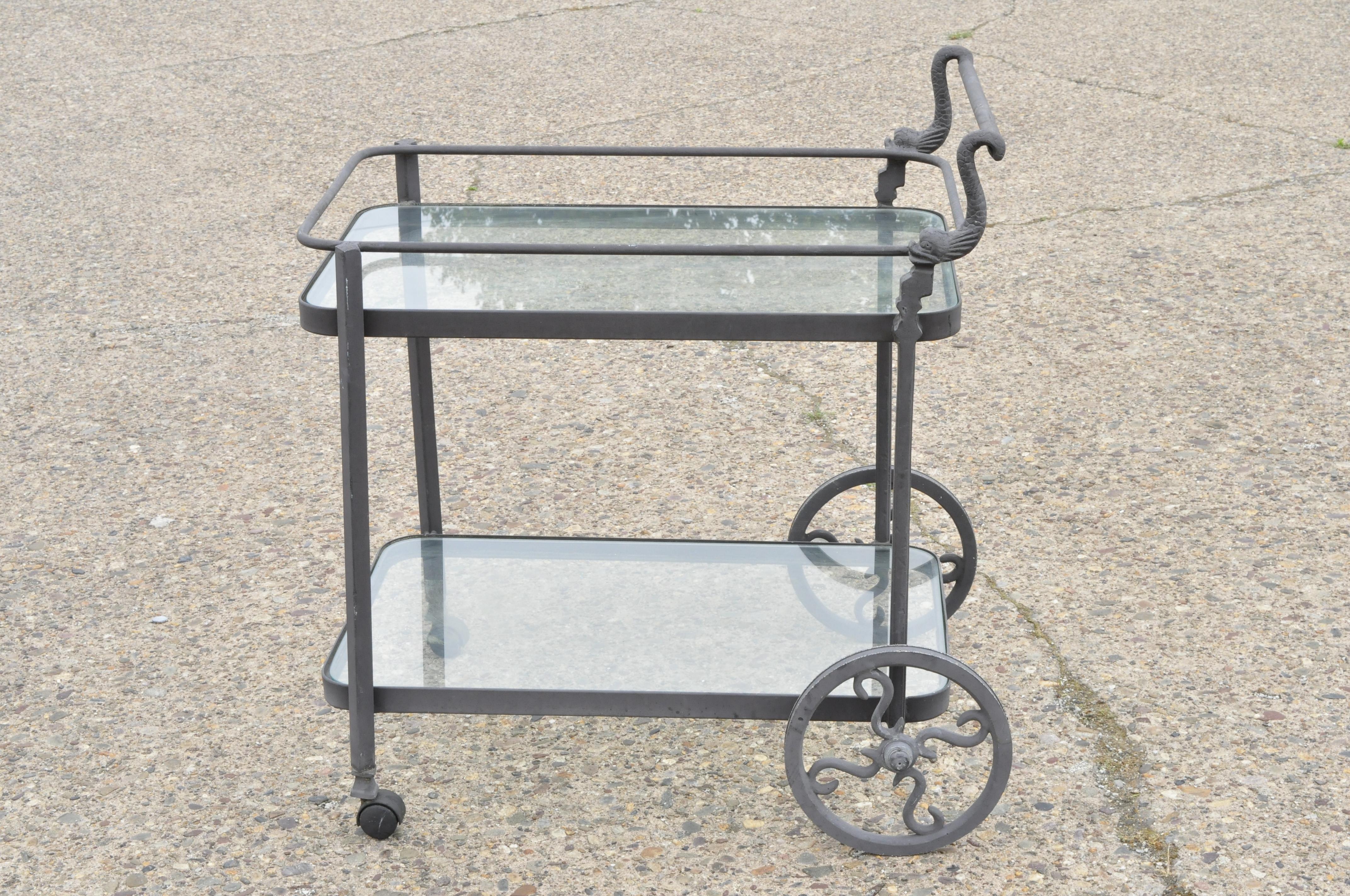 Cast aluminum 2-tier rolling bar cart server with fish dolphin handle. Item features 2 glass tiers, dolphin/fish handle, cast aluminum construction, great style and form, circa late 20th century. Measurements: 36.5