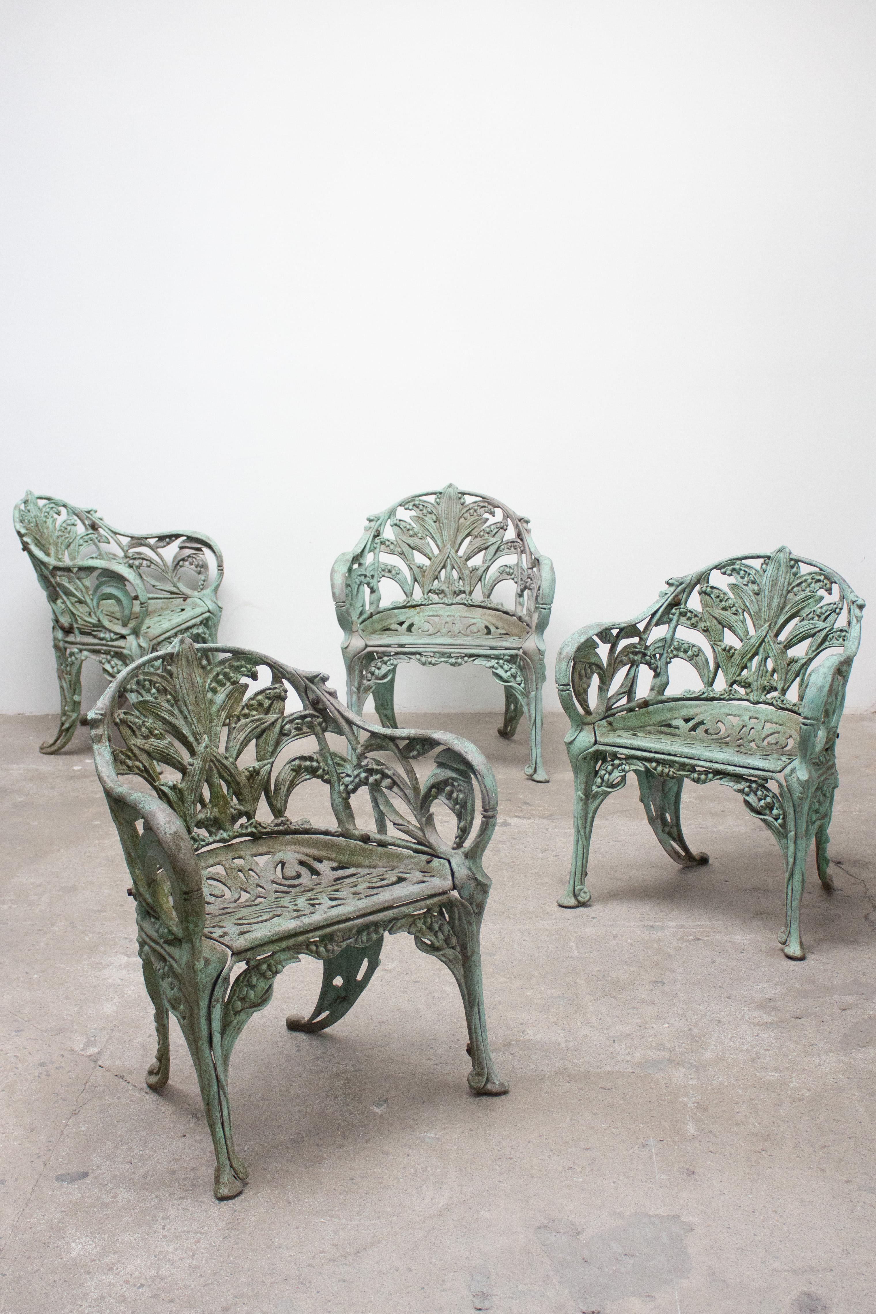 A set of four cast aluminum garden chairs. Victorian style with a lily of the valley pattern. Wonderful aged patina throughout shows losses of teal paint, mossy patches and color variations. Sourced from a Great Neck, Long Island estate.