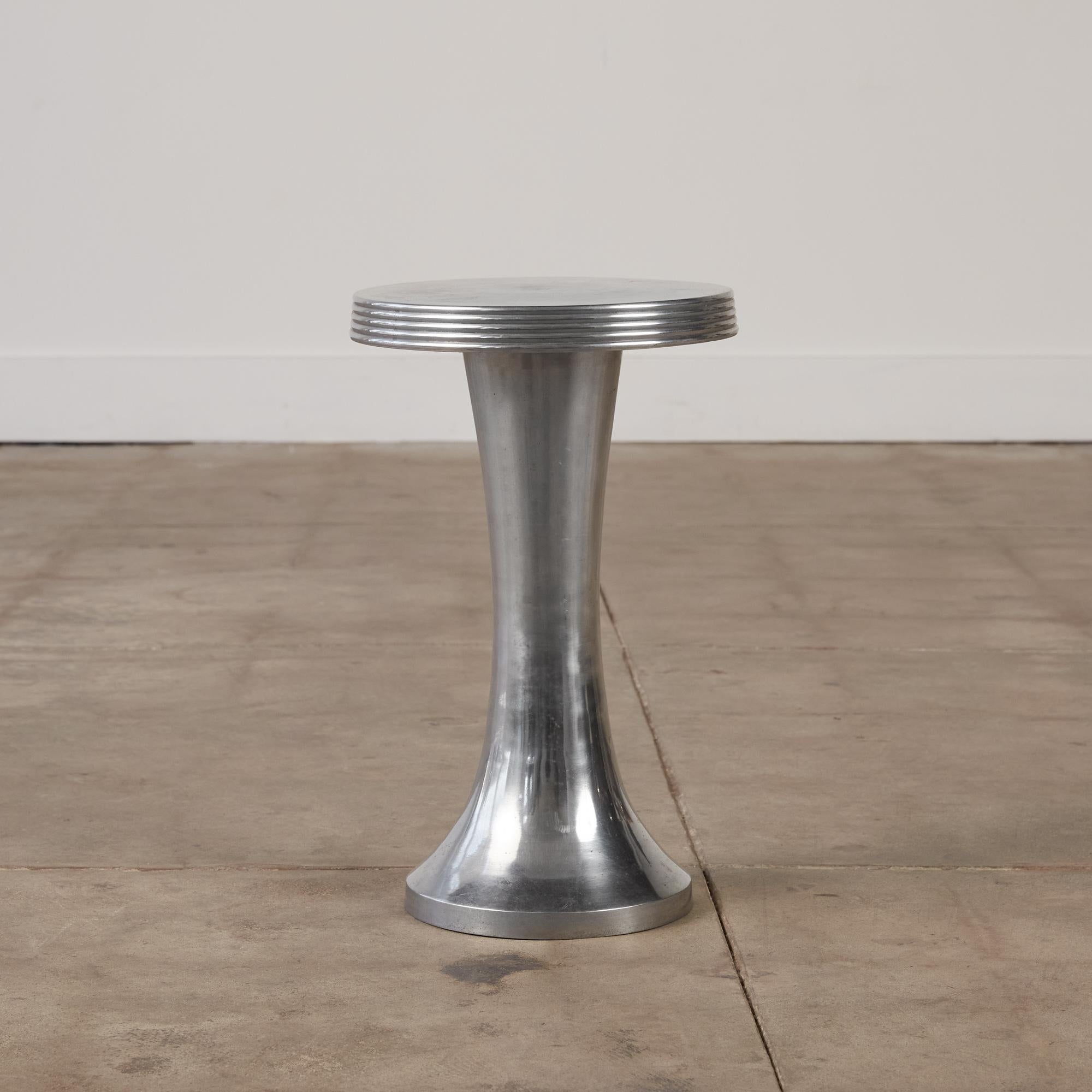 Pedestal table made of cast aluminum with a flared base. The tabletop has a stacked fluted detail all around, a characteristic commonly seen in designs in the Art Deco and Postmodern era. A perfect piece to rest a cocktail or book.

Dimensions: