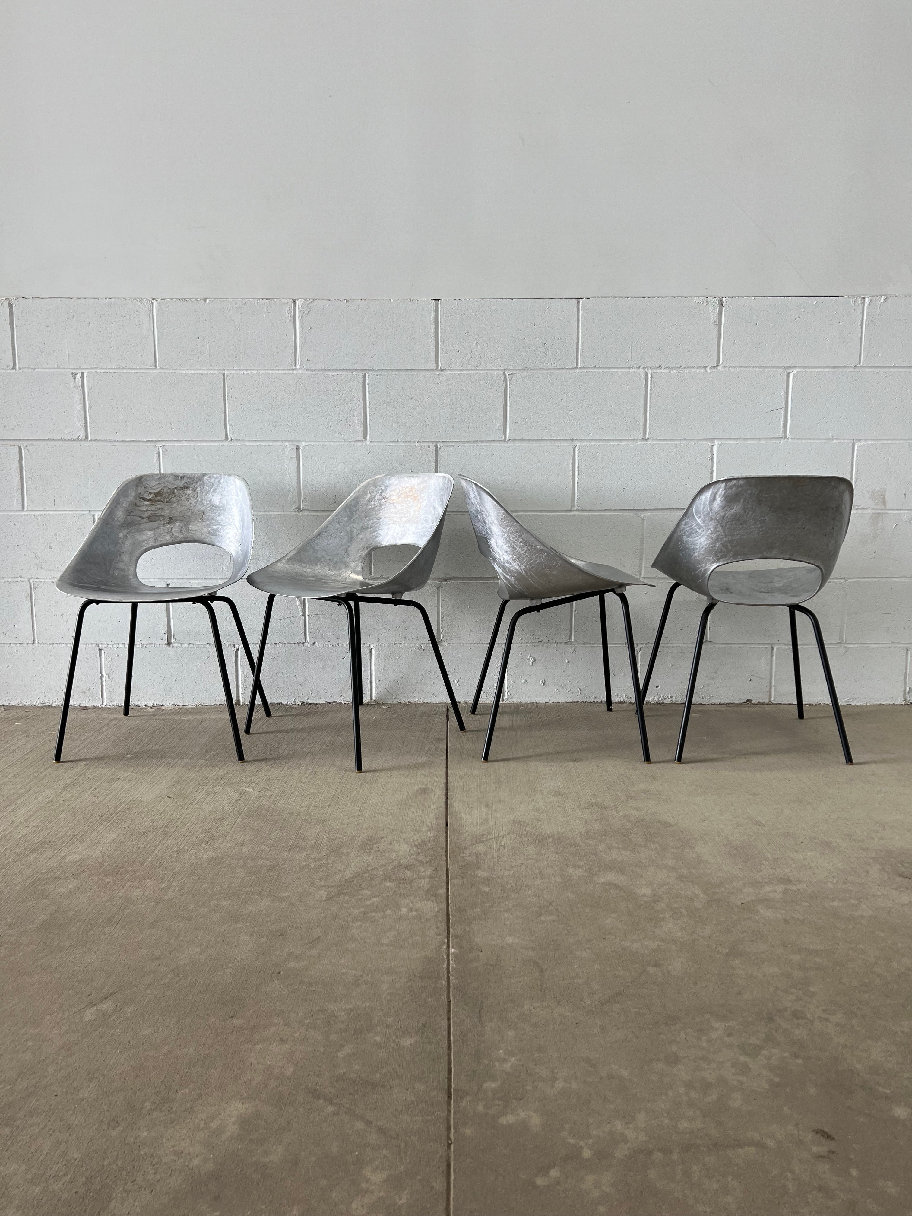 A standard of French design, the Tulipe chair by Pierre Guariche has been a rising star and is approaching the desirability of his contemporaries' designs. 

These chairs are in raw cast aluminum. All hardware, feet, and bases are original.