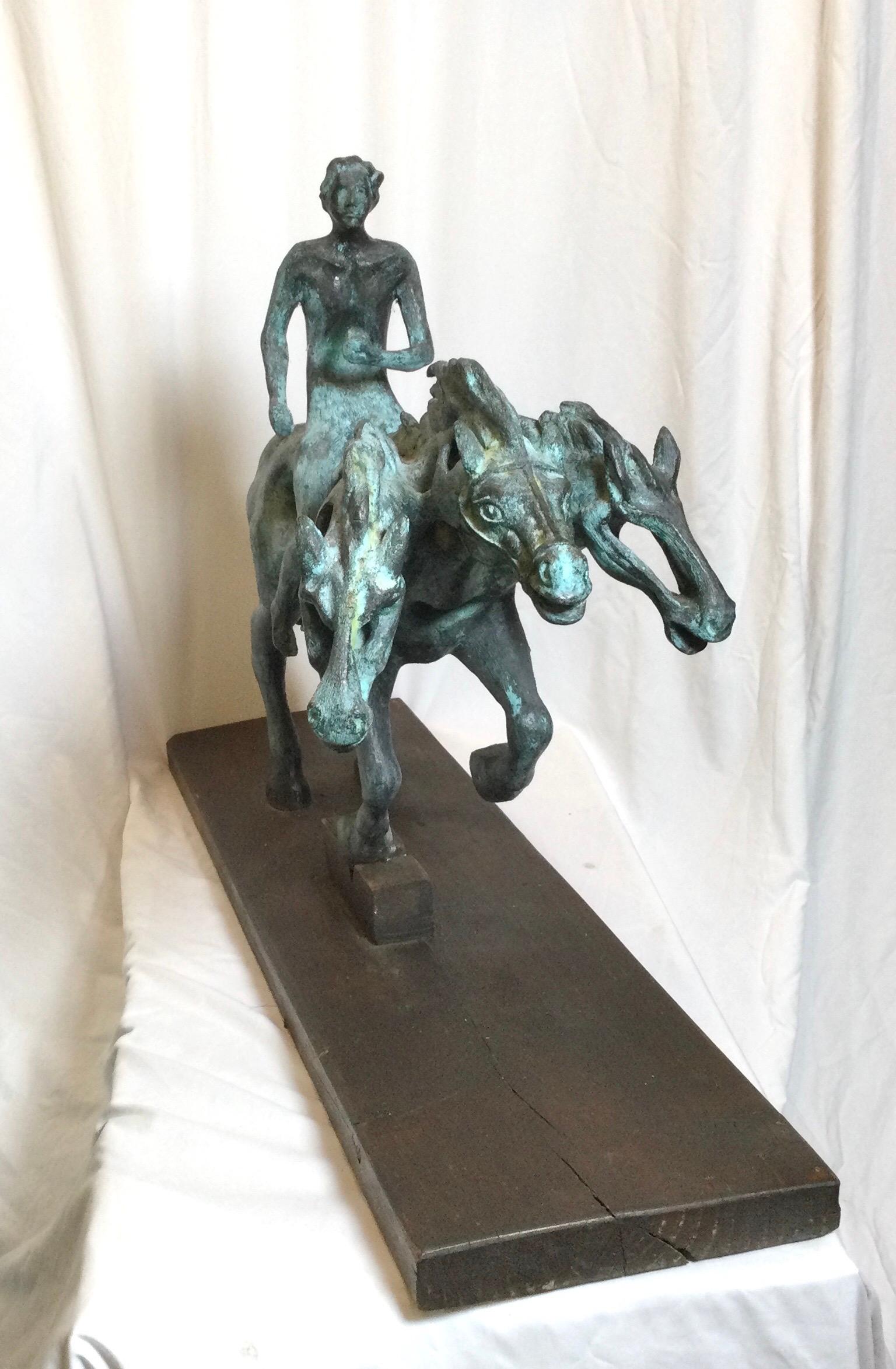 A Latin American aged patinated bronze of a surrealist horse and rider. The cast bronze sculpture on attached wood base.