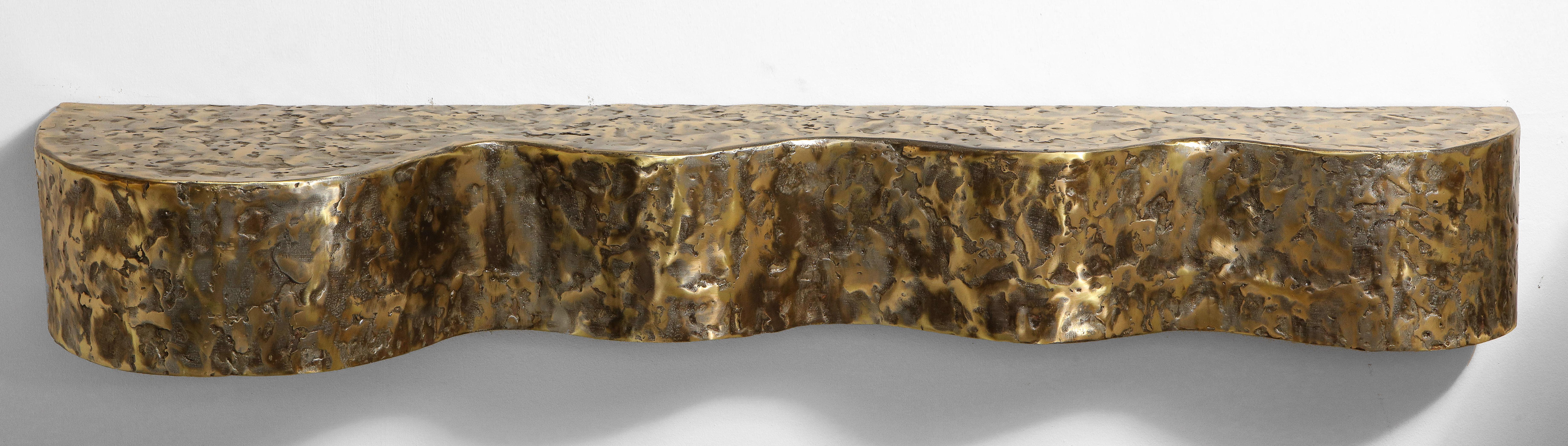 The organic undulating formed table cast and fabricated in bronze, brass, pewter and steel. Mounted on a its original bracket. 

Signed Silas Seandel.