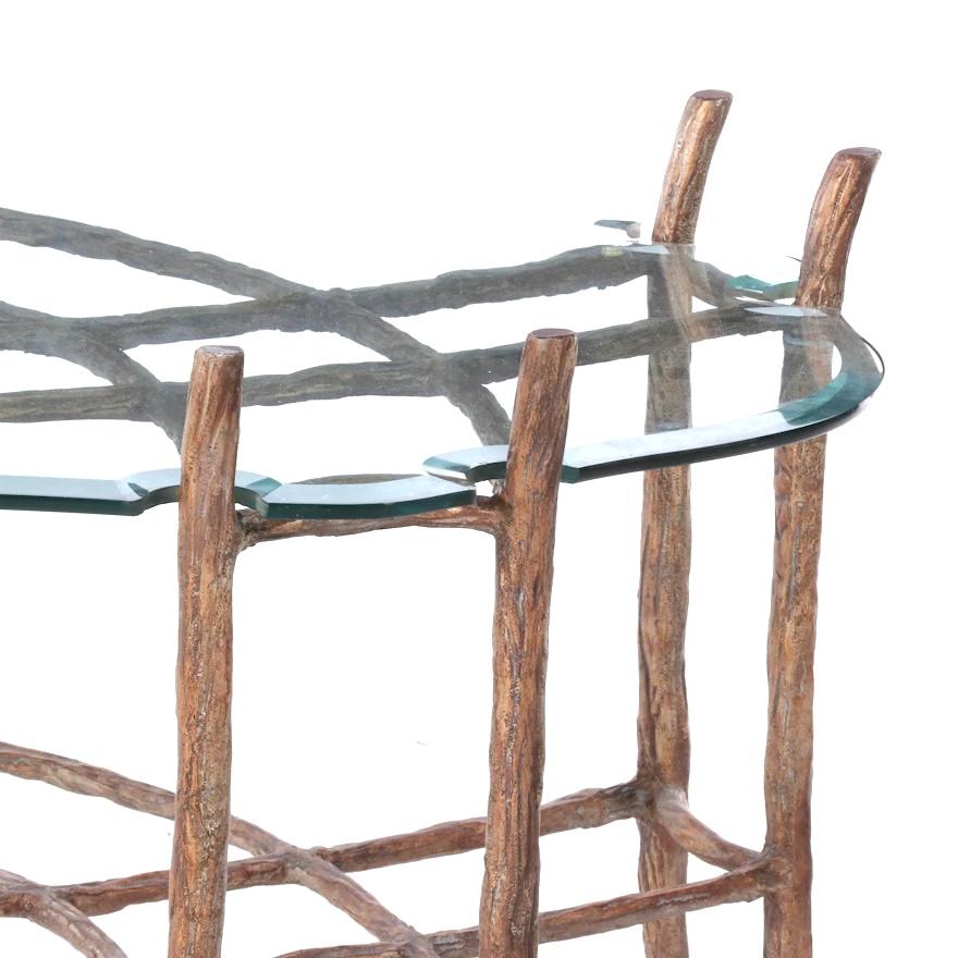 Cast aluminum and hand painted faux bois finished glass top coffee table. At first glance this beautiful coffee or cocktail table appears to be made of tree branches. The faux bois finish is quite realistic. The beveled glass top is cut to fit the