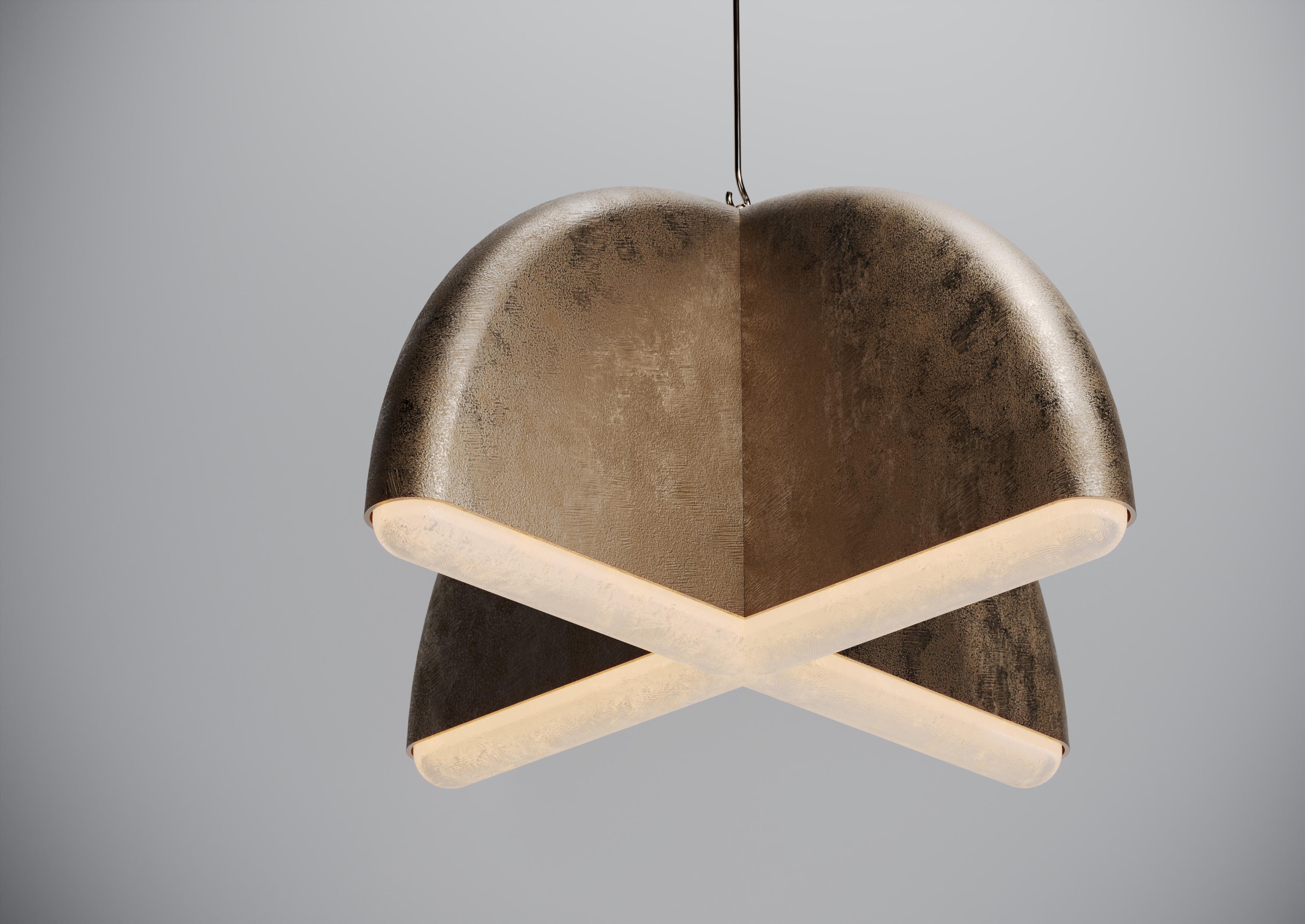 Una scultura luminosa a forma di croce sospesa in sabbia con bordi lucidi e diffusore in vetro. Il lampadario è composto da quattro elementi strutturali in metallo massiccio fuso a sabbia che si illuminano all'interno della loro forma a conchiglia e