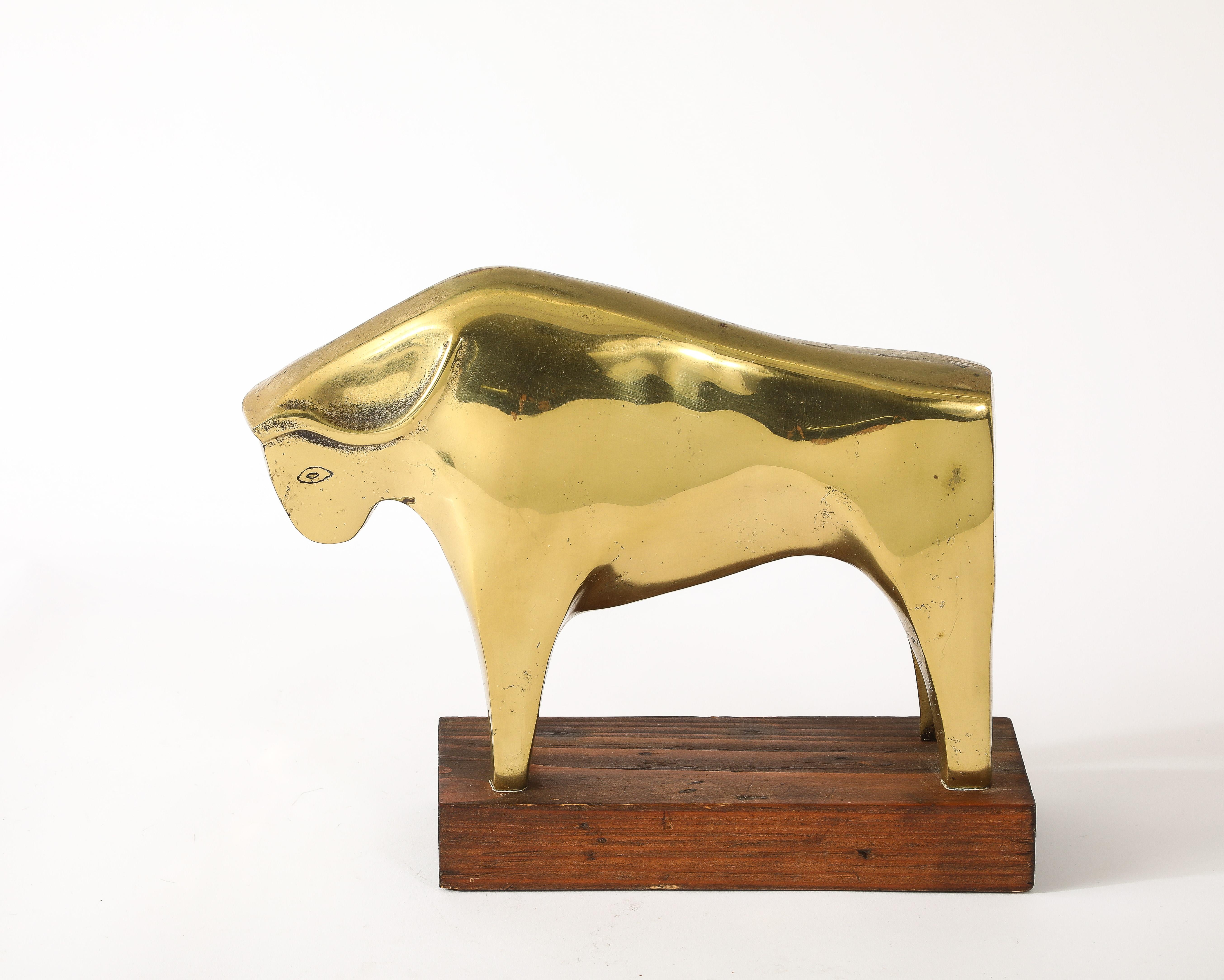 An abstract cast brass Ox on a mahogany plinth.