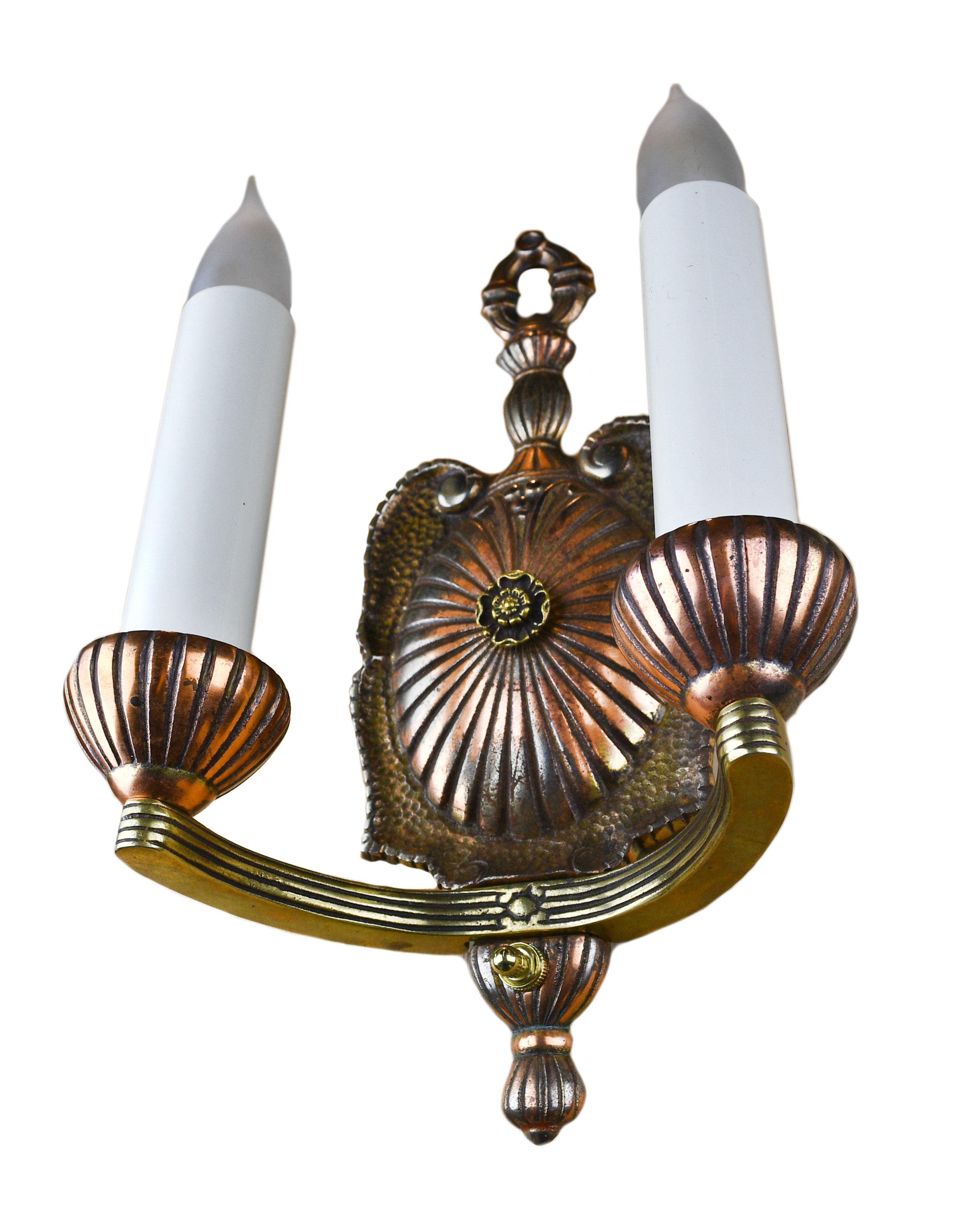 This sconce is made of lovely 2-tone brass and features a winding symmetrical design with a lovely flower button on the backplate,

circa 1920s
Condition: Good
Material: Brass
Finish: Original
Country of origin: USA
Illumination: 2 standard