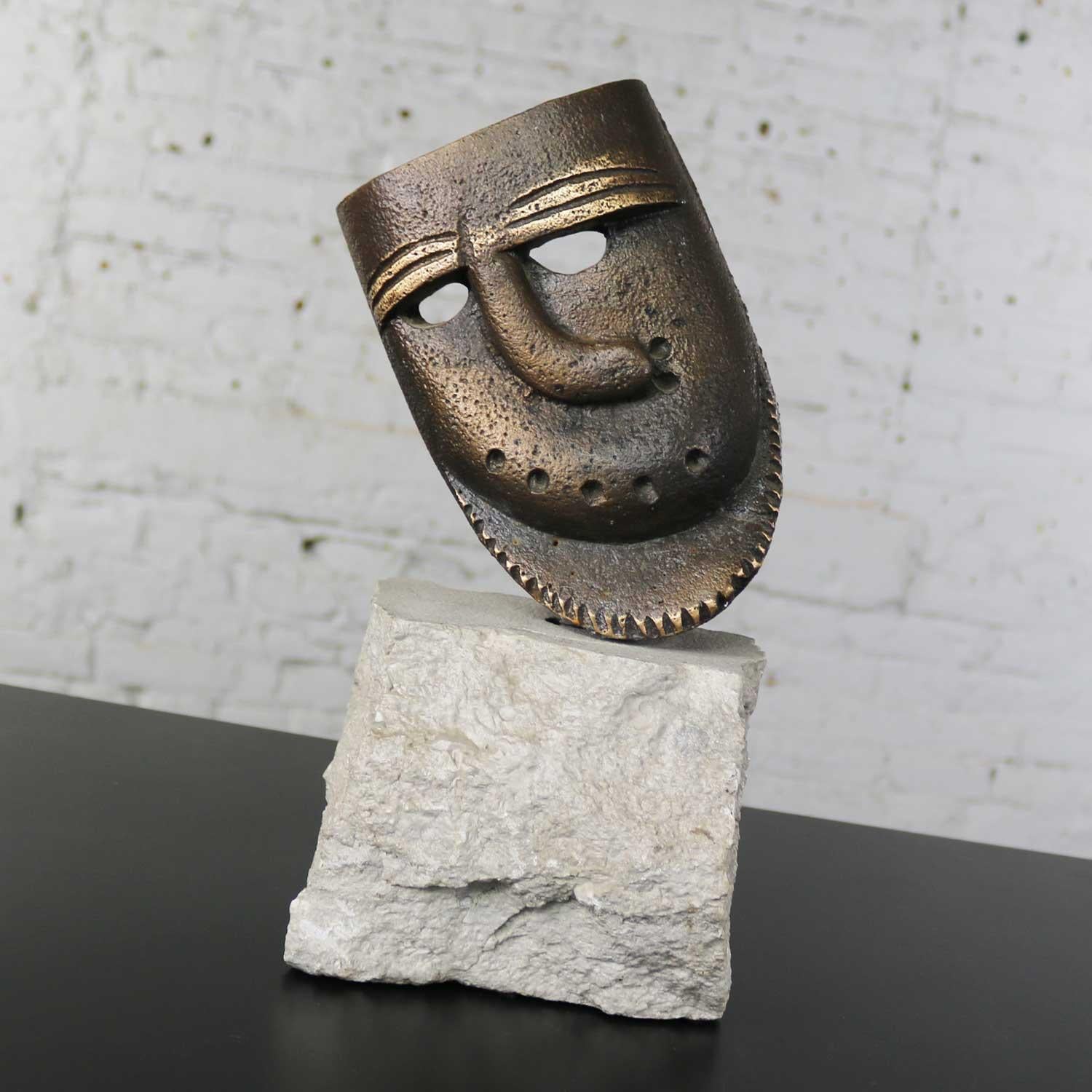 Handsome cast bronze sculpture of African mask with a crooked nose. It is mounted permanently on a chunk of cut limestone with natural edge. It is in fabulous vintage condition, circa 1990s.
What a handsome and interesting object d’art! It will