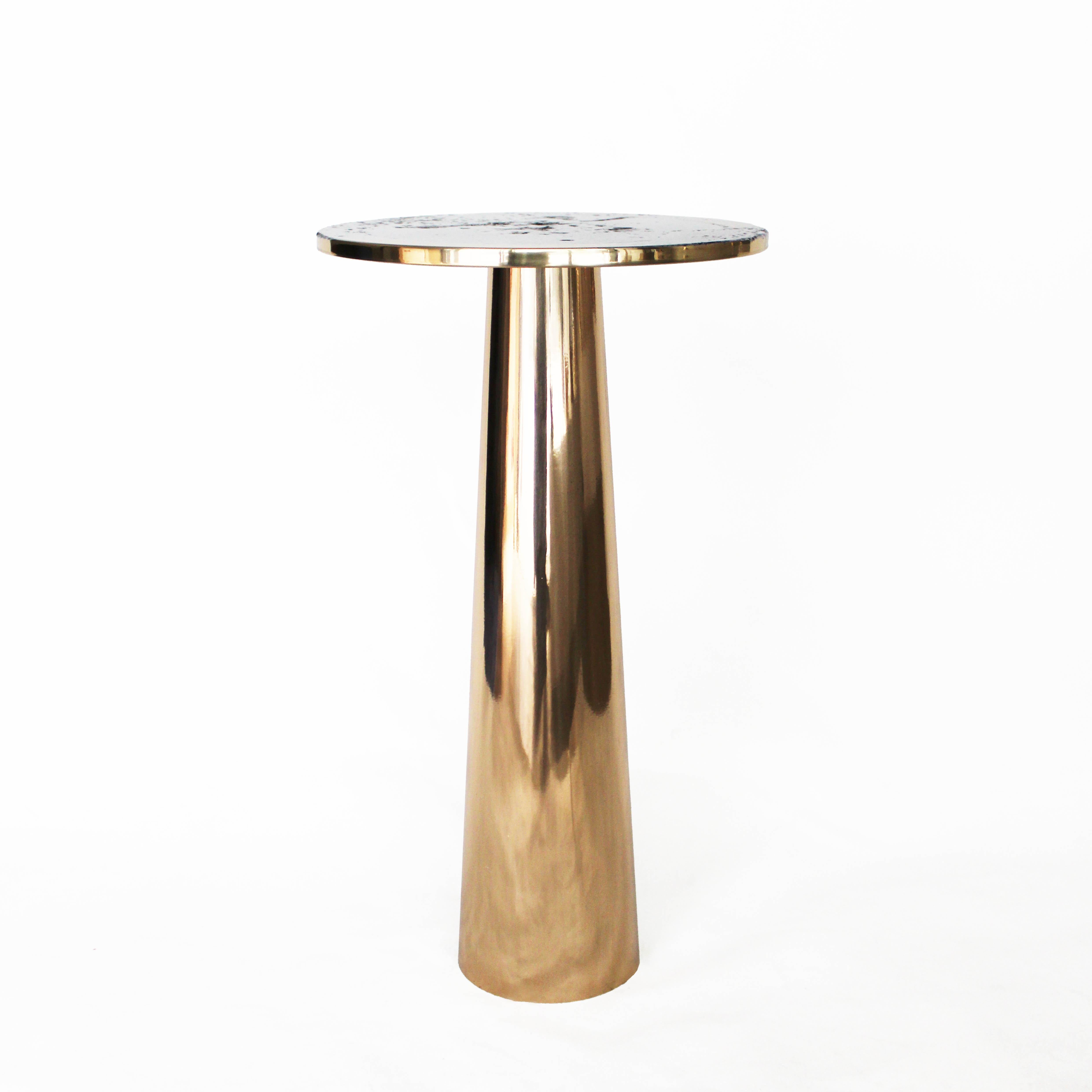 The Cone Table is inspired by the interconnections between the elements and life forms. 
The conical shape of the base, the asymmetrical form of the top, and the rounded edges provide the table with a silky appearance.

Cone Table, made of bronze or