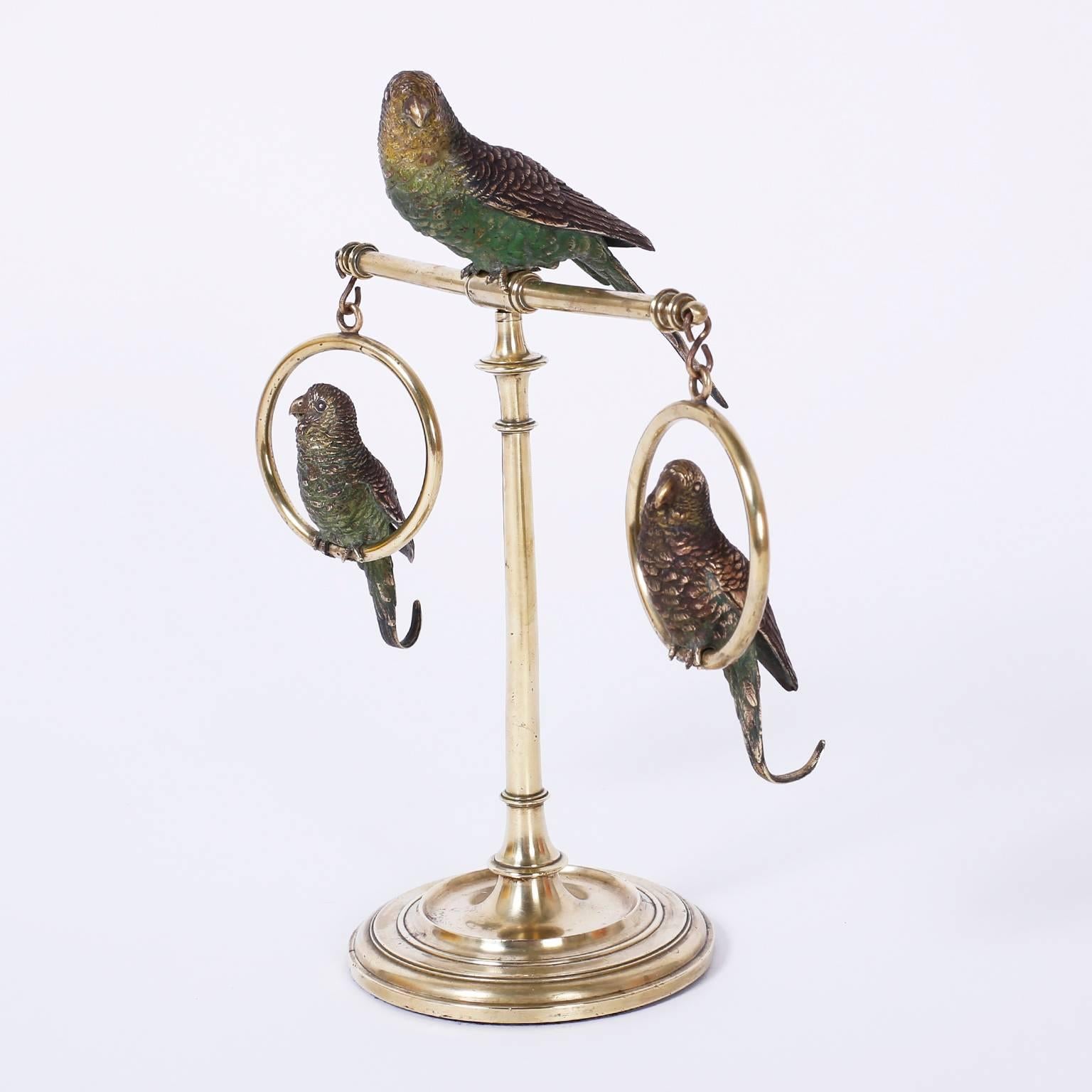 Tres periquitos o pájaros de bronce vienés fundido y pintado en frío posados sobre un soporte de latón con base torneada clásica, a la manera de Franz Bergman.