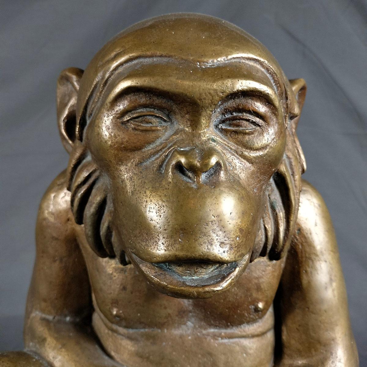 Una scultura di scimpanzé in bronzo fuso del 1990 circa. L'immagine ritrae lo scimpanzé con un'espressione calma, persino riflessiva. La scultura non è firmata né marcata.
