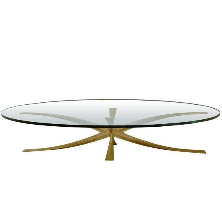 A cast bronze coffee table with oval glass top by Michel Mangematin.

French, Circa 1960's

