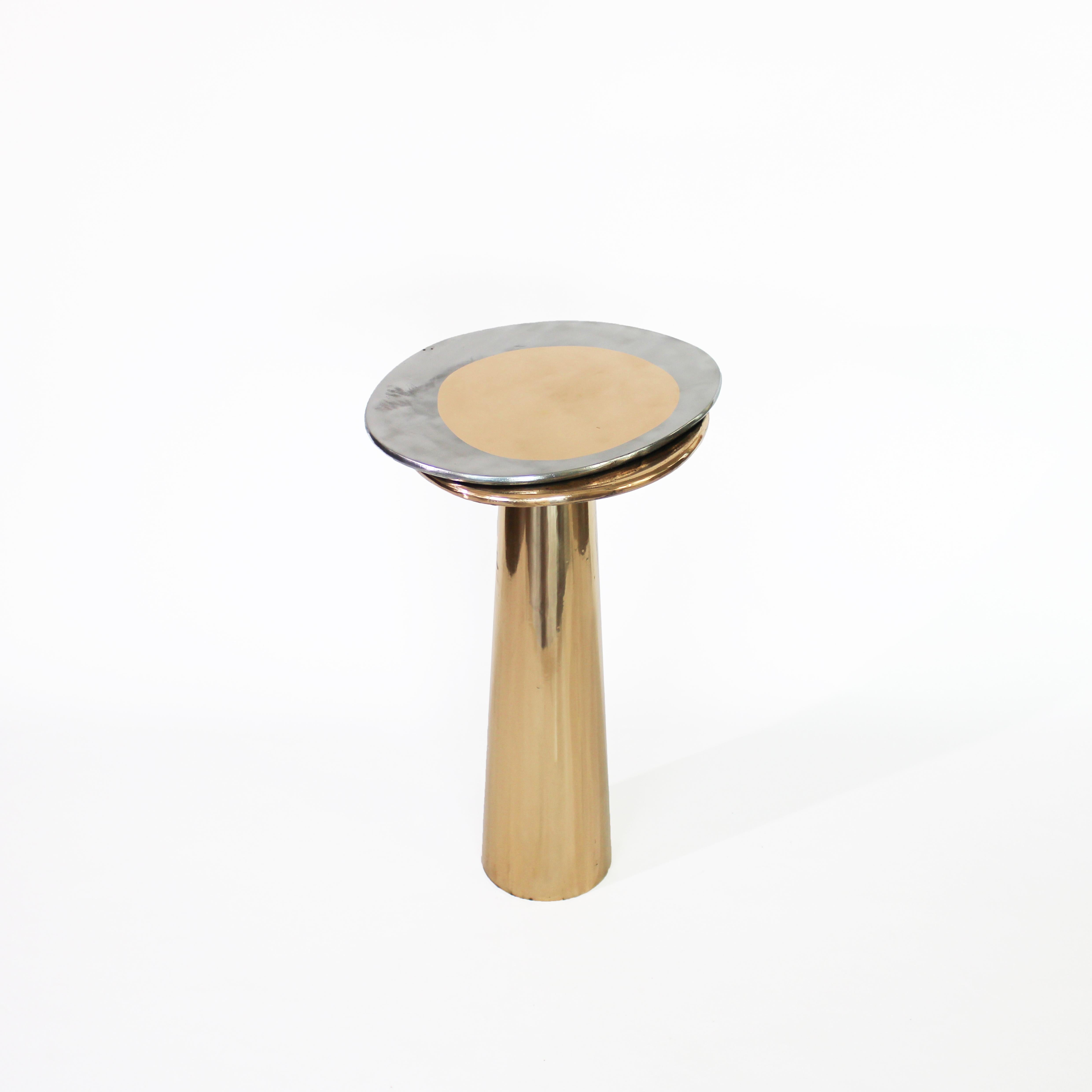 The Cone Table is inspired by the interconnections between the elements and life forms. 
The conical shape of the base, the asymmetrical form of the top, and the rounded edges provide the table with a silky appearance.

Cone Table, made of bronze