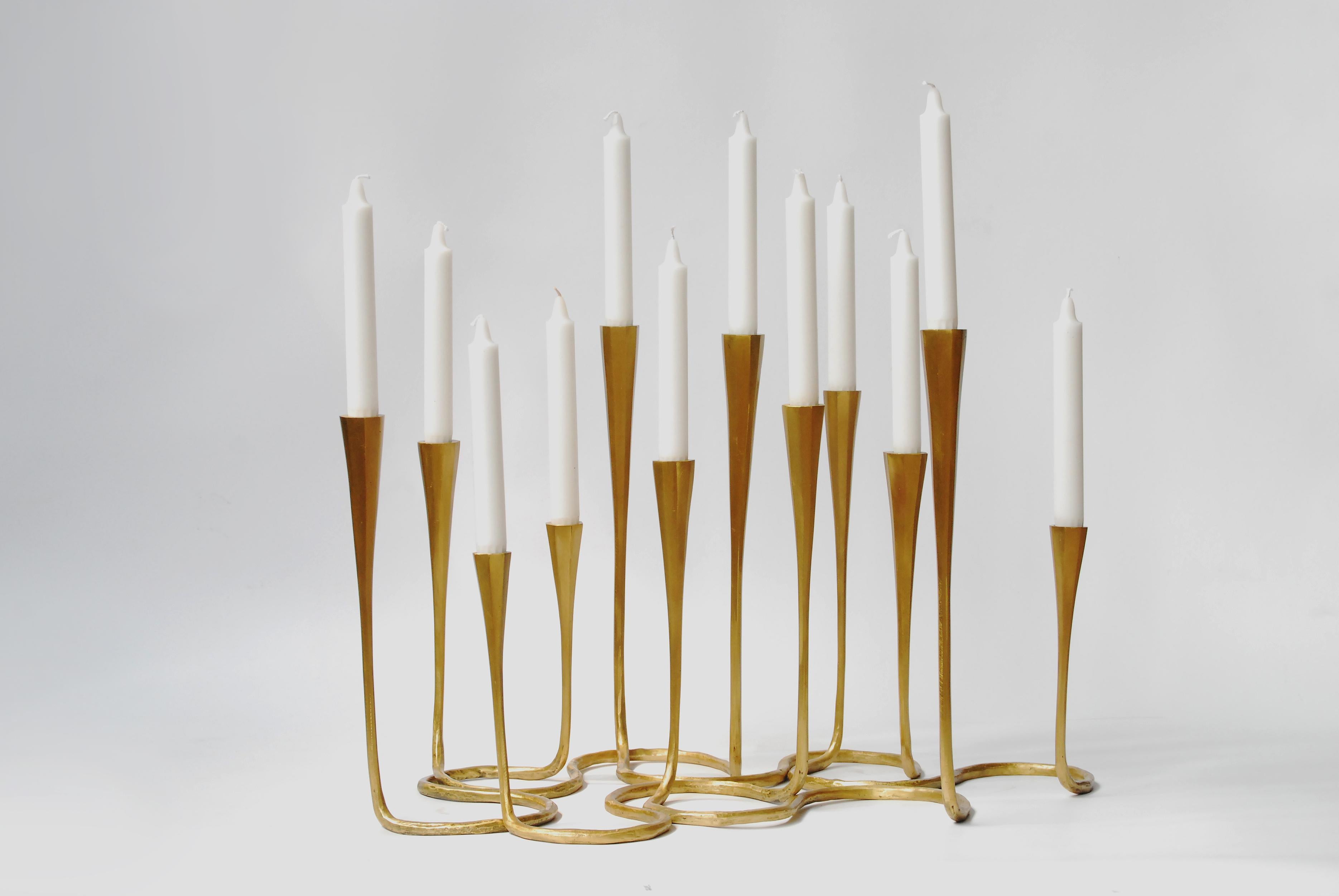Gold bronze daisy candlestands are cast using the lost wax method. Each daisy comes as a set of two candlestands joined at the base. Combine several to create a stunning candlelit display on tabletops. Available in custom finishes and sizes by